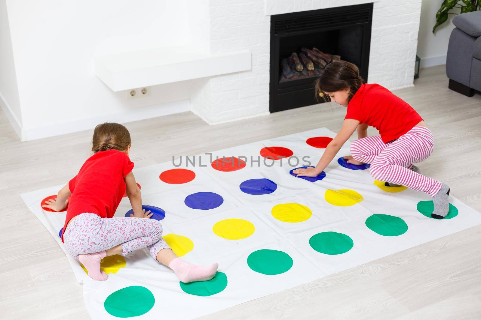 two little girls Having Fun Playing Game On Floor At Home. Siblings Friendship by Andelov13