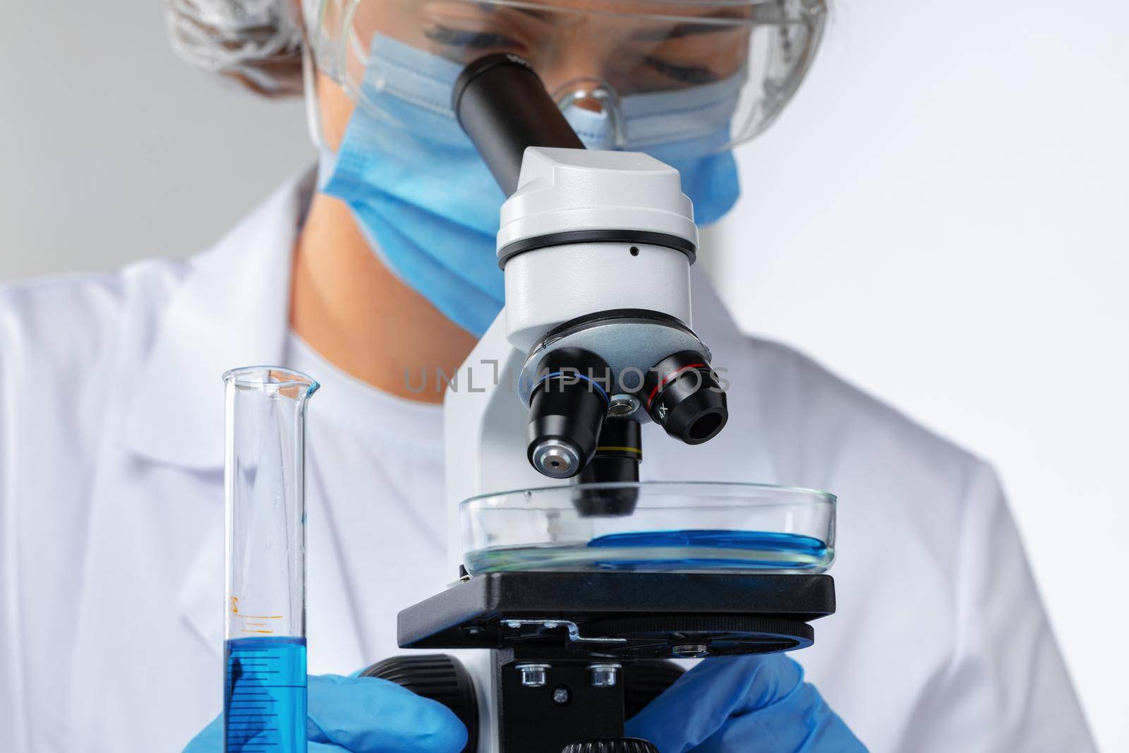 Close up photo of woman scientist working with microscope in laboratory