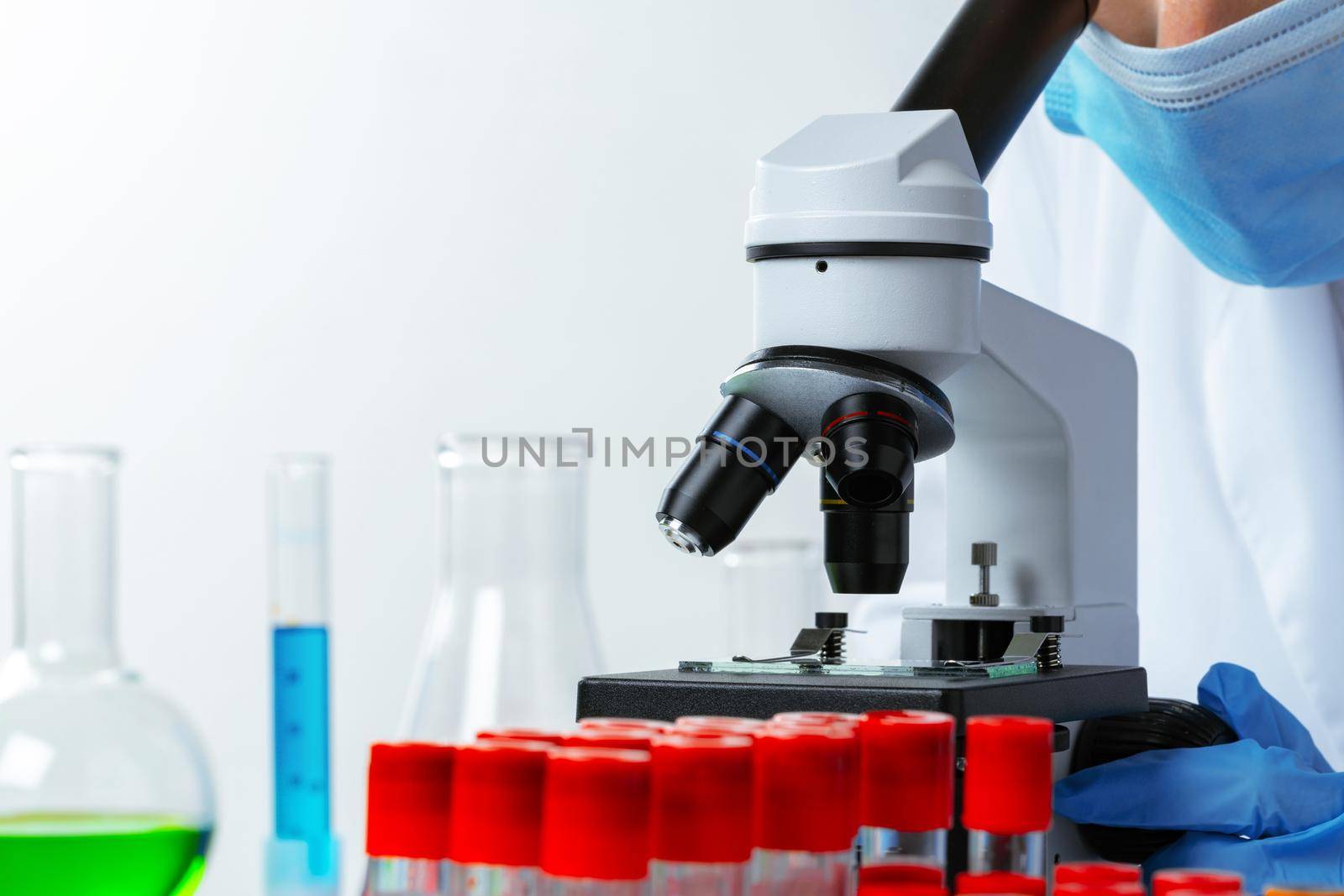 Close up photo of woman scientist working with microscope in laboratory