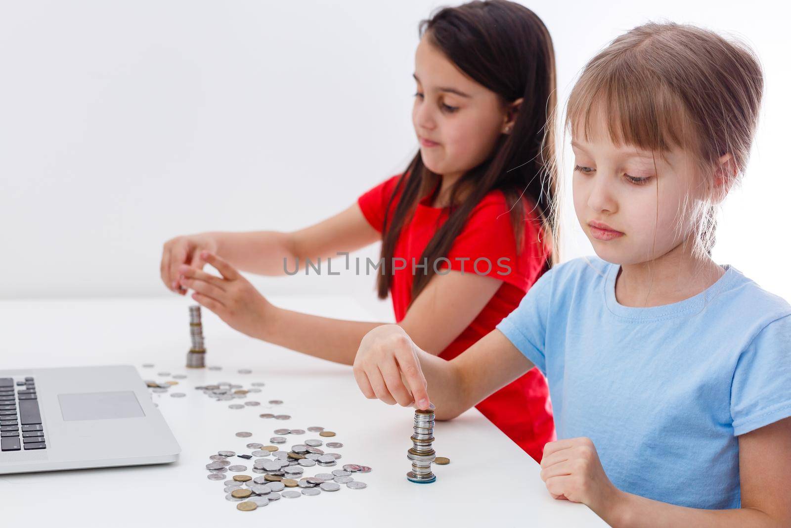 portrait of little girls sitting at table and calculating money