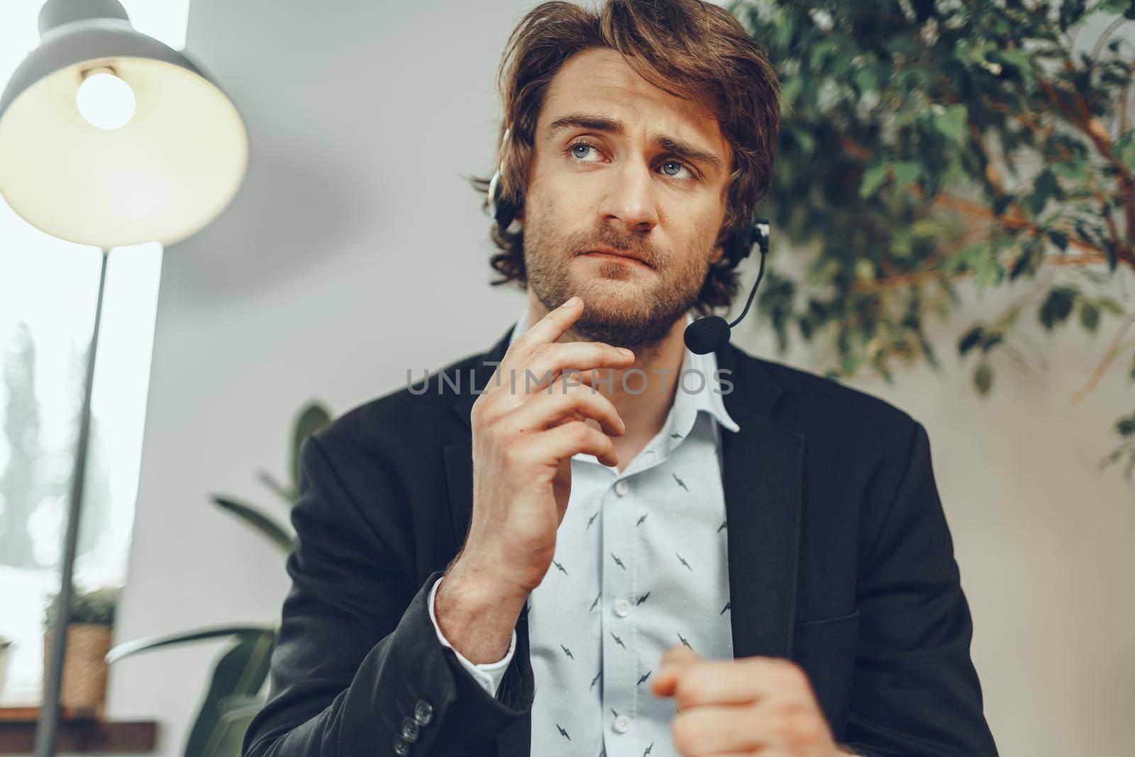 Close up portrait of an angry businessman with headset having stressful annoying online conversation