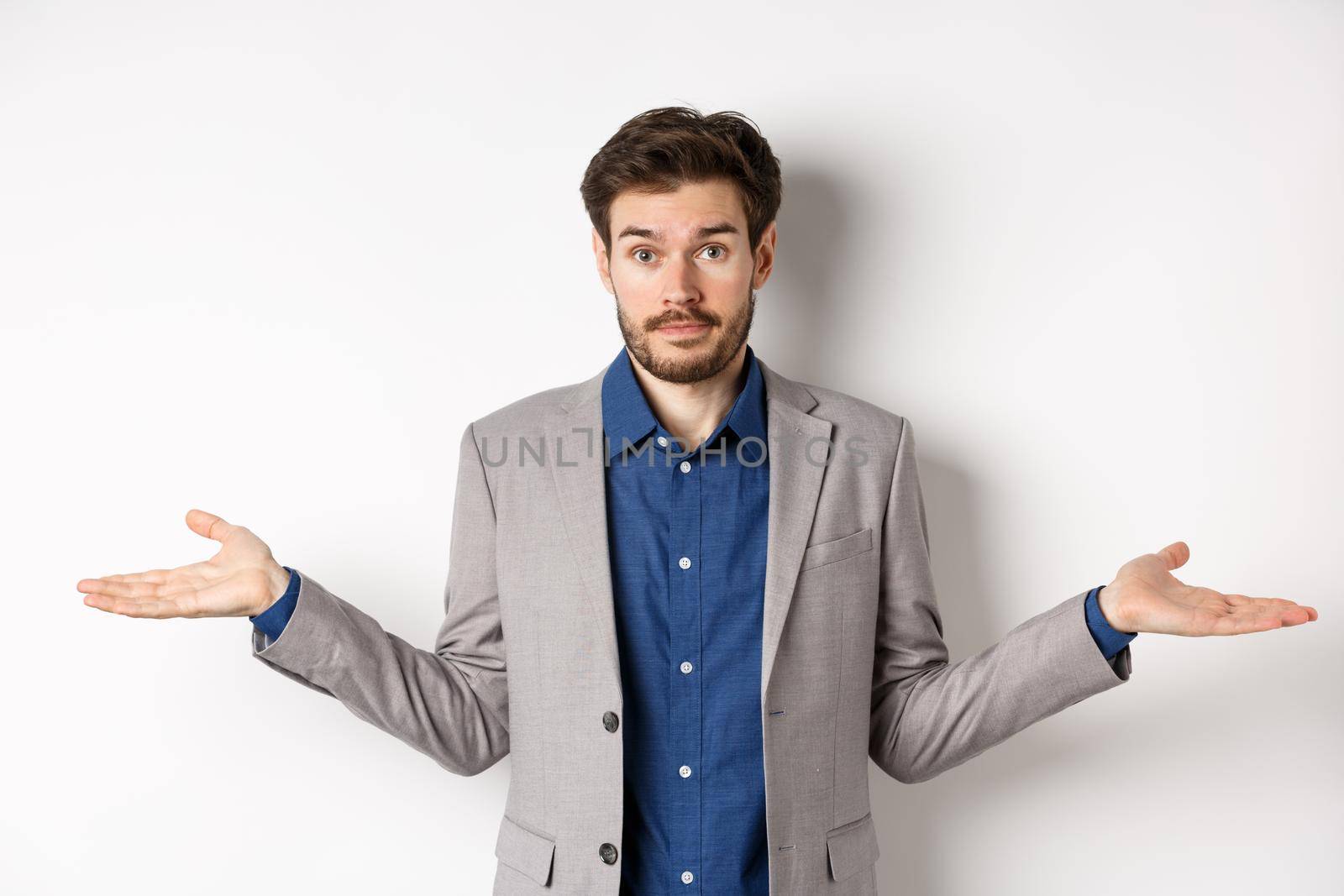 Dont know. Confused businessman spread hands sideways and look clueless, cant help, have no idea, standing on white background in suit by Benzoix