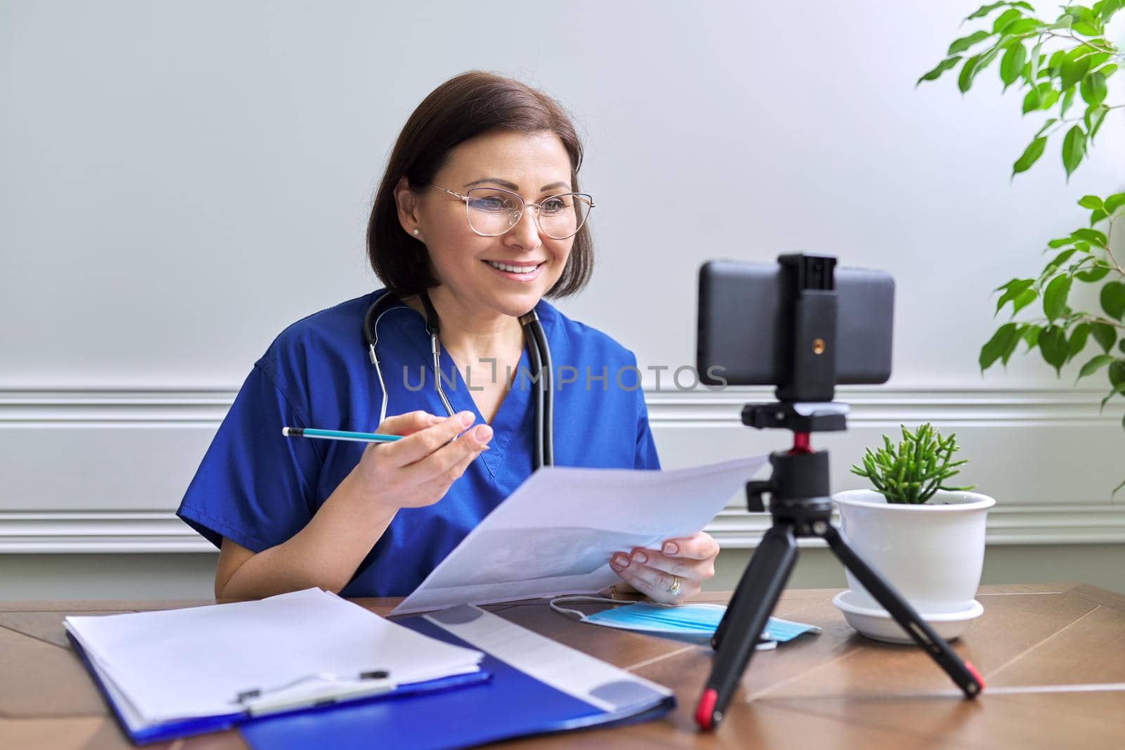 Online doctor consultation, female talking with patient using video call by VH-studio