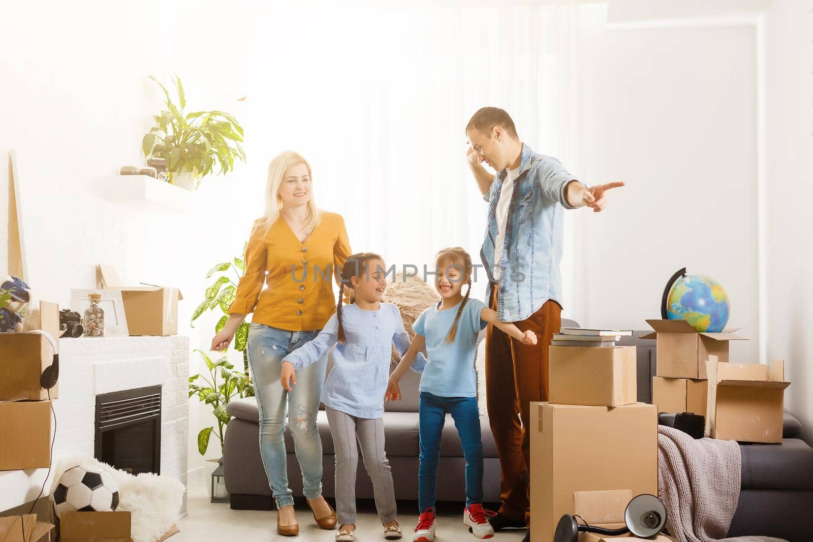 Family with cardboard boxes standing in row at home
