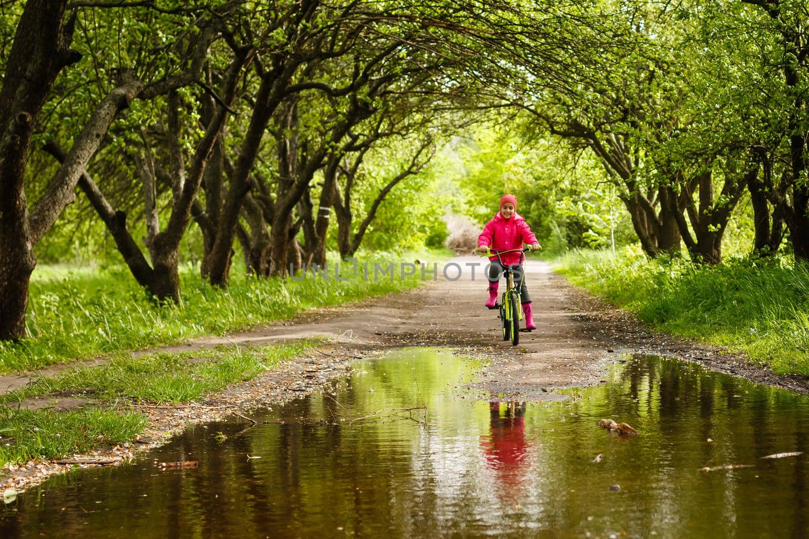 little girl riding bike in water puddle