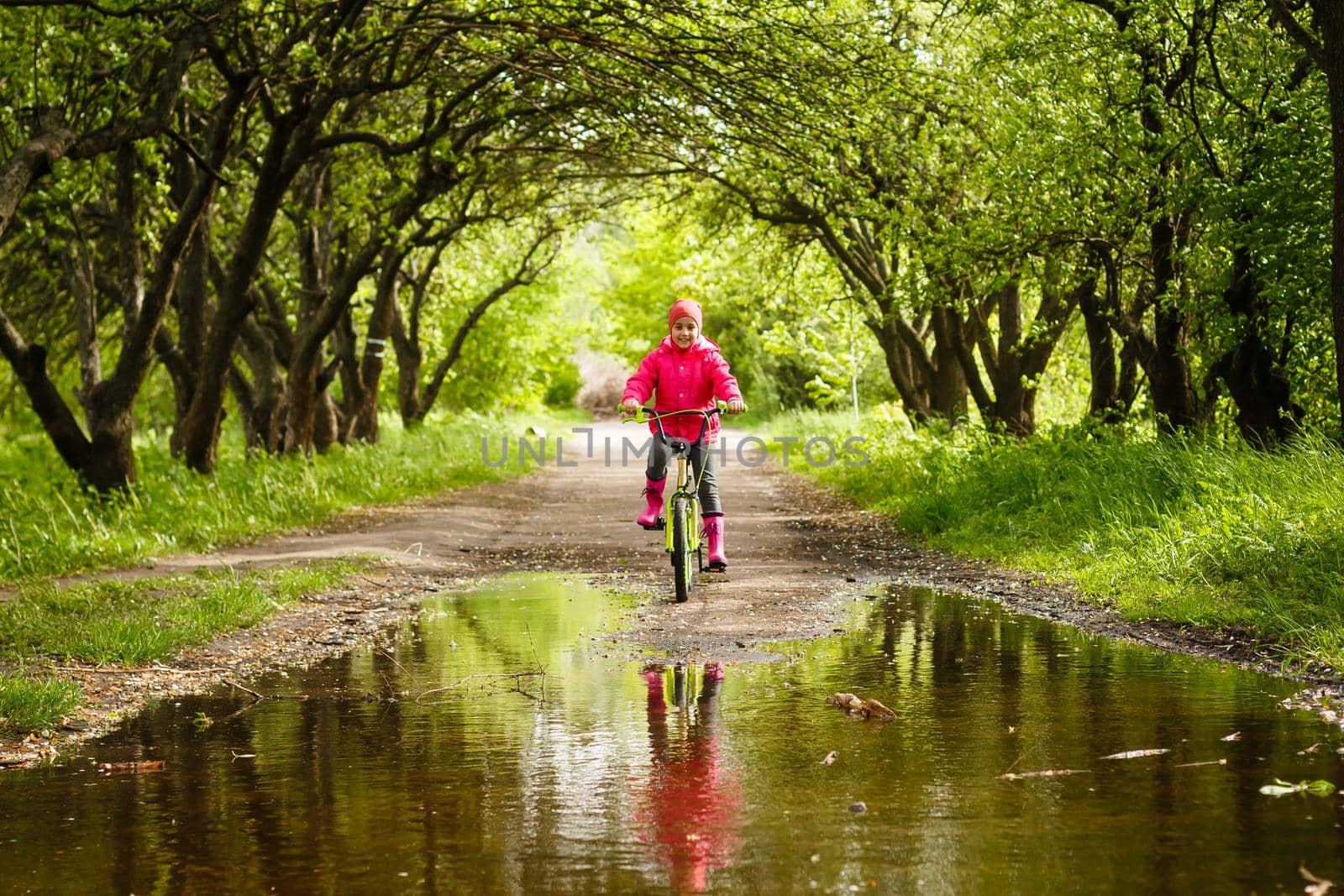 little girl riding bike in water puddle