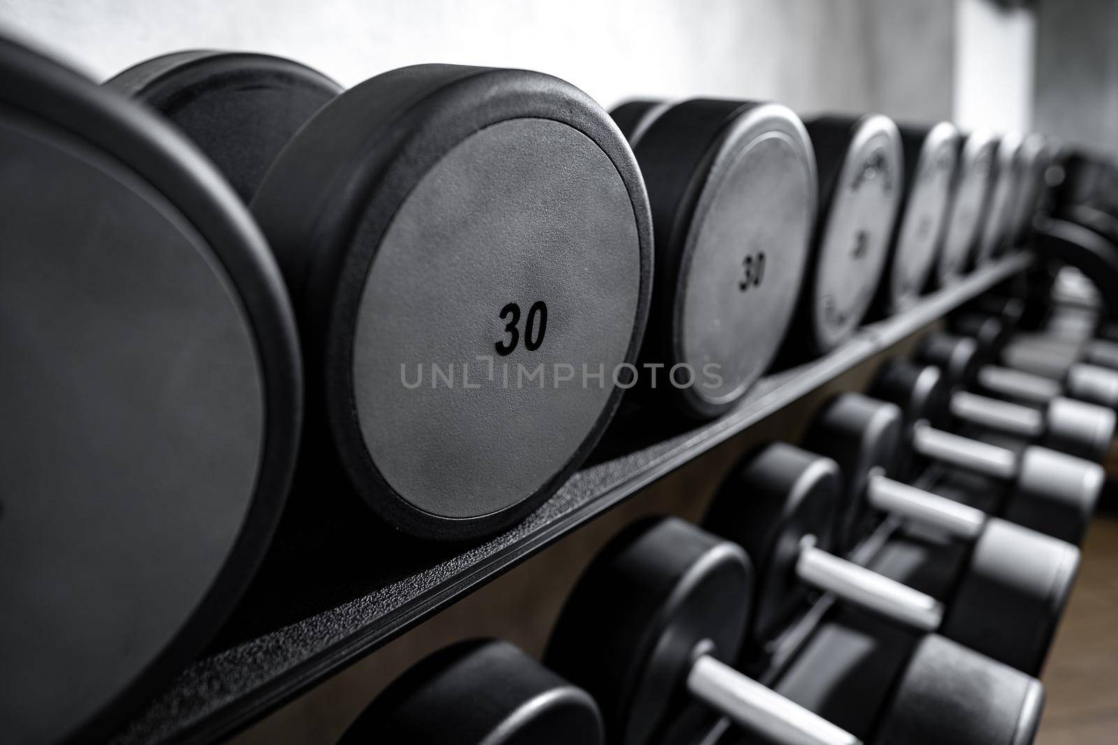Close up photo of new dumbbells on a rack in a gym