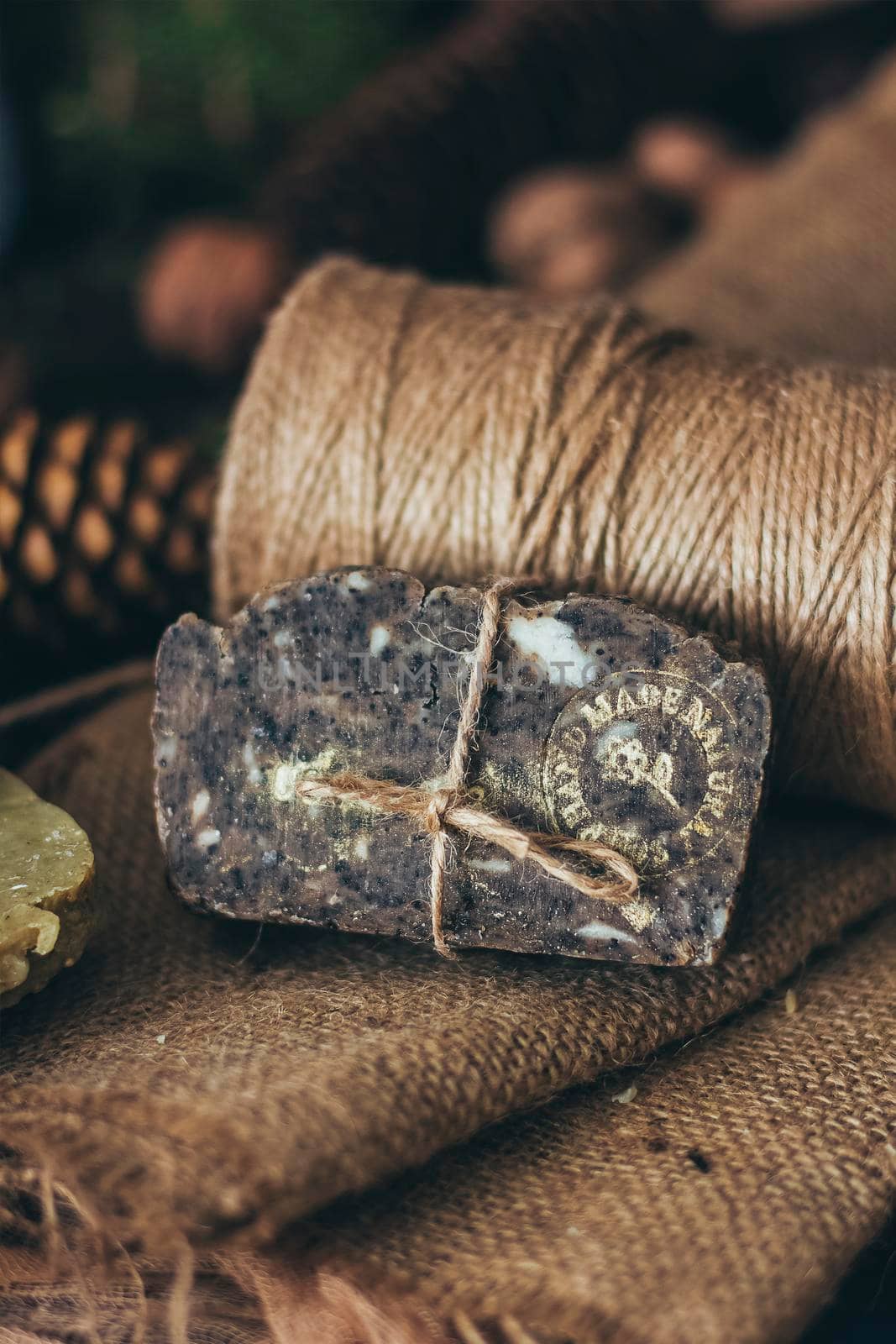 Pieces of beautiful natural handcrafted soap on wooden background with botanical elements, close up view. For relax, health, spa and aromatherapy