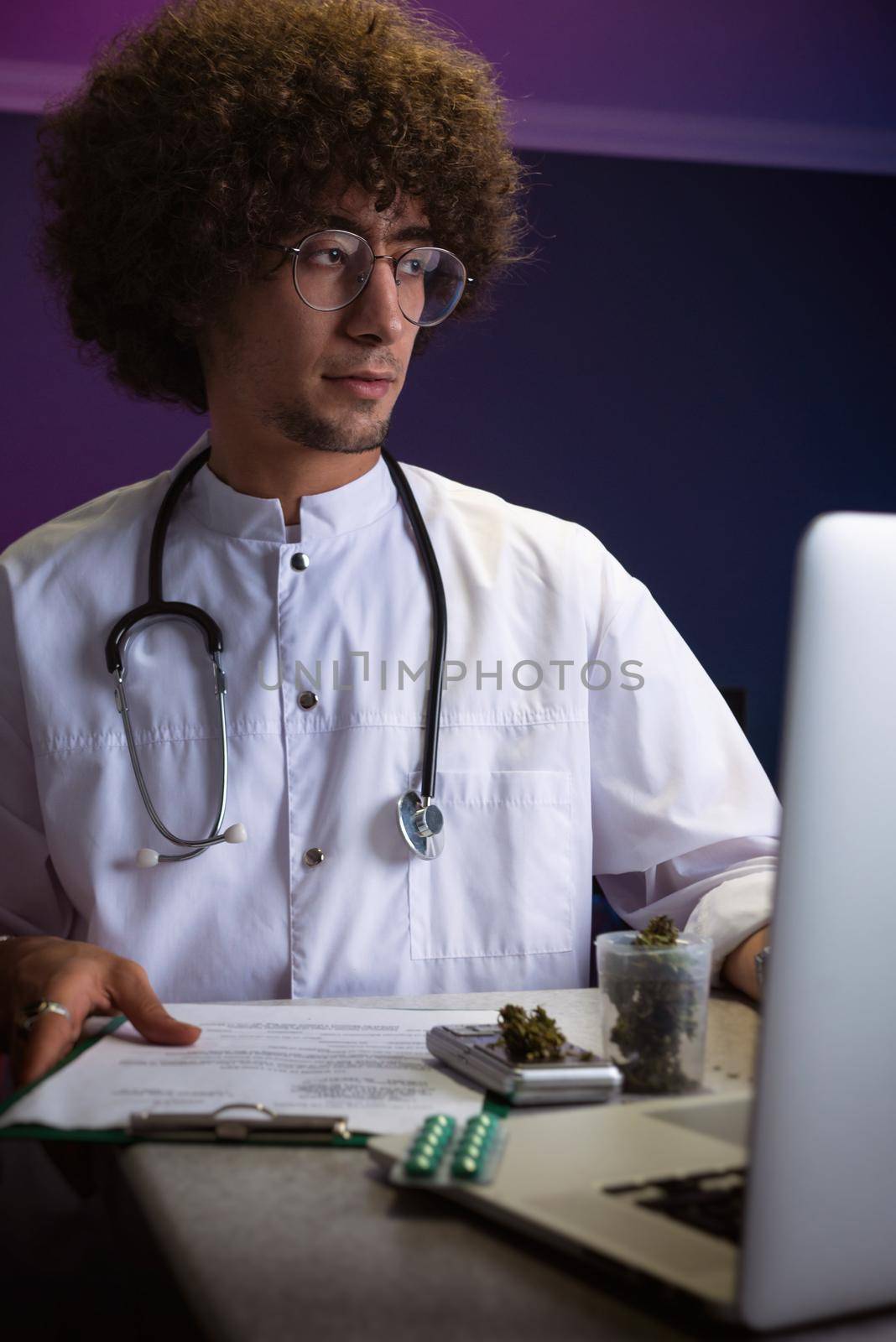 an Arab student with an Afro hairstyle in a doctor's suit is engaged in cannabis research