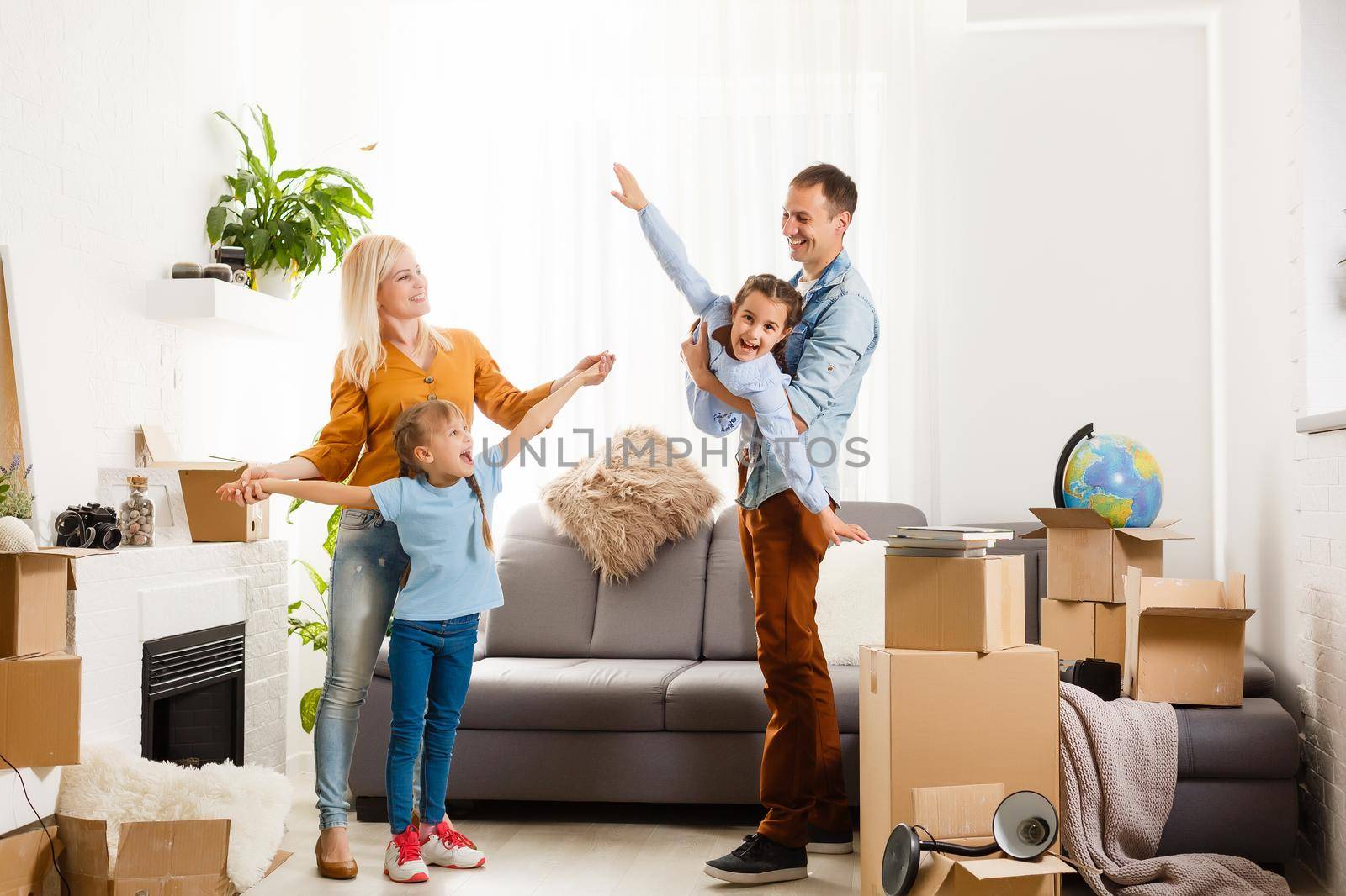 Happy family moving home with boxes around by Andelov13
