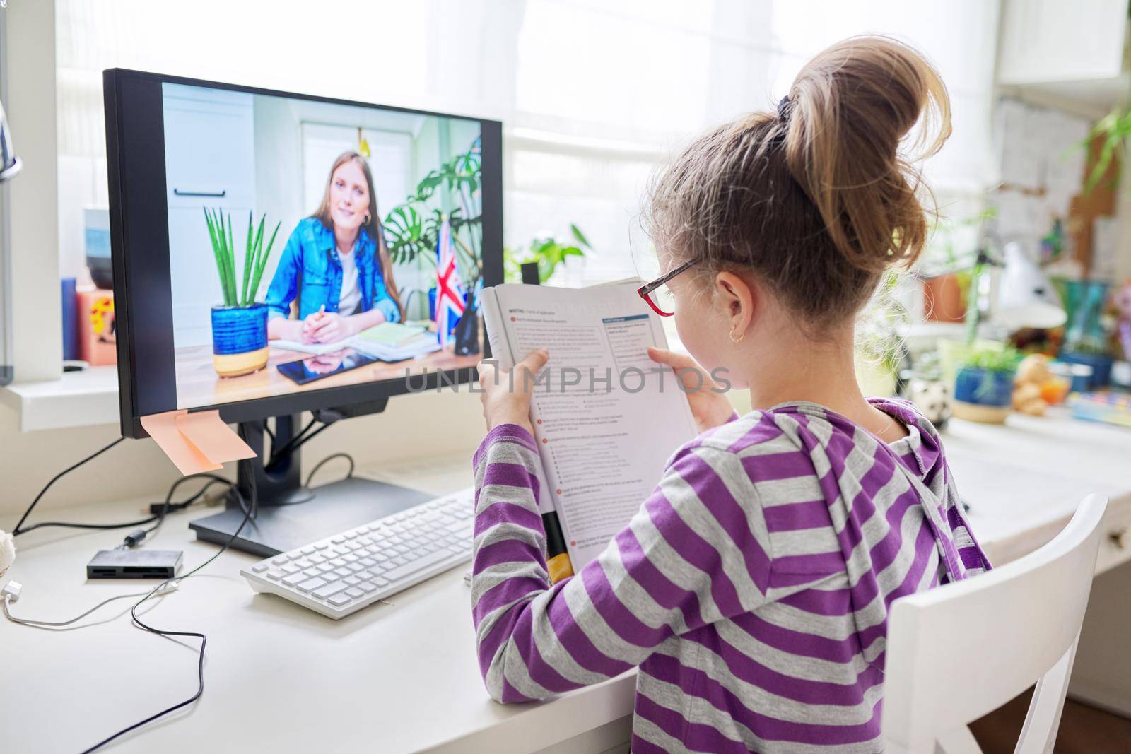 Online learning, children, little student girl learning language remotely with an English teacher. E-education, modern technologies in education, school concept