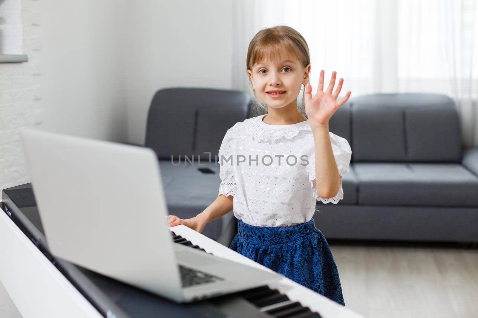 Little girl learning the piano during quarantine. Coronavirus concept.