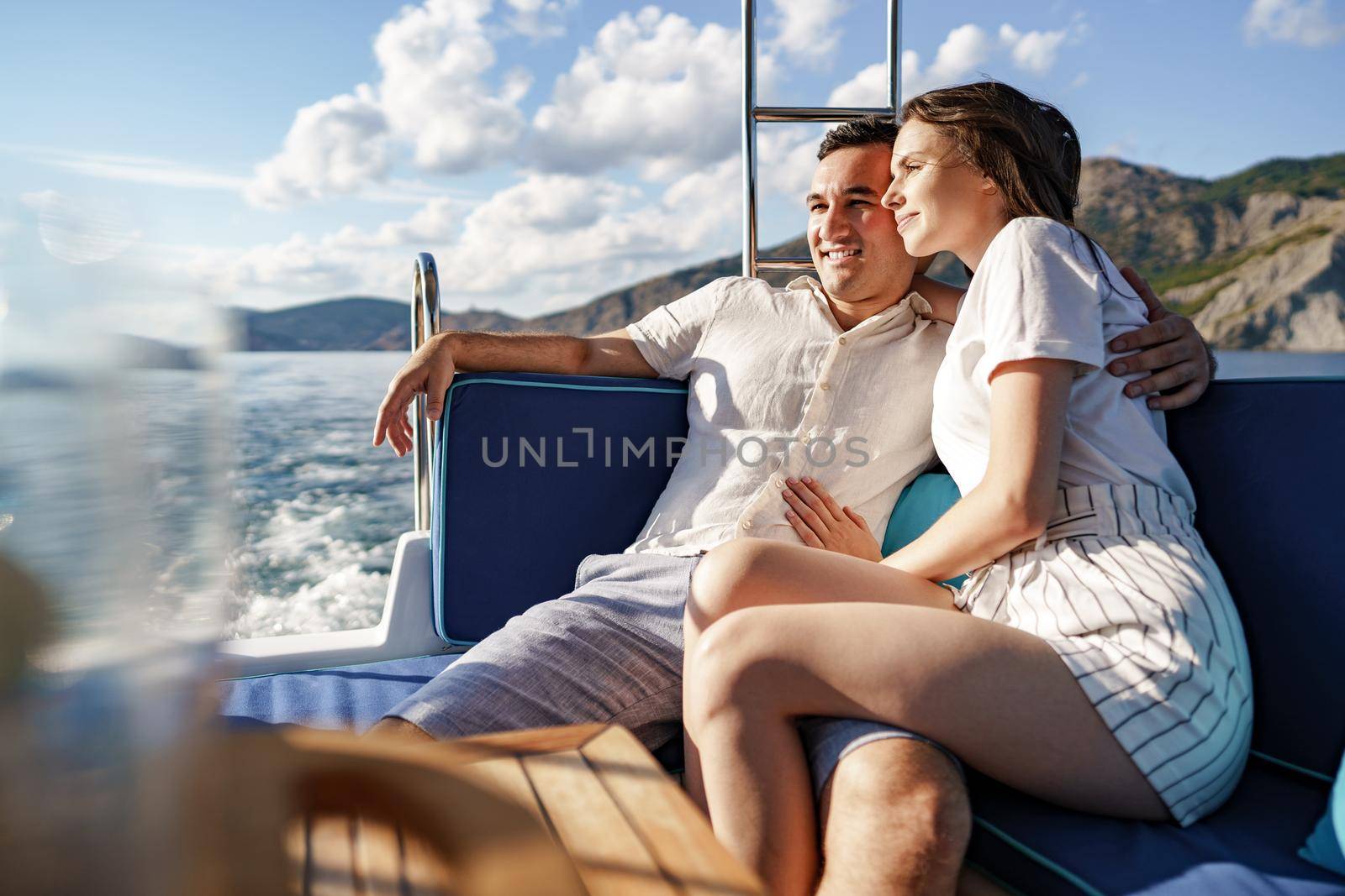 Happy couple in love on a yacht in summer on romantic vacation