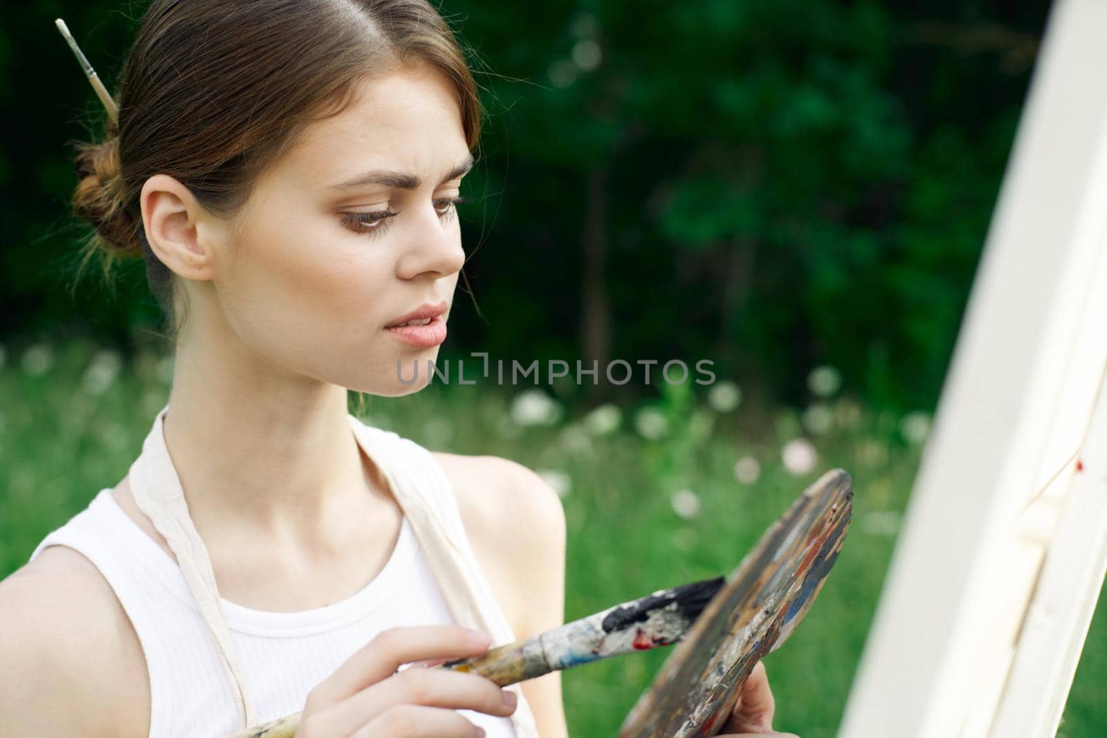 woman artist in white dress paint palette drawing close-up. High quality photo
