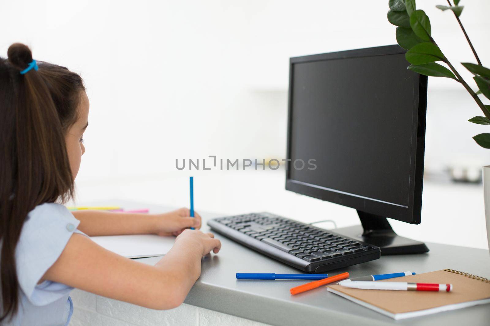 Pretty stylish schoolgirl studying homework math during her online lesson at home, social distance during quarantine, self-isolation, online education concept, home schooler