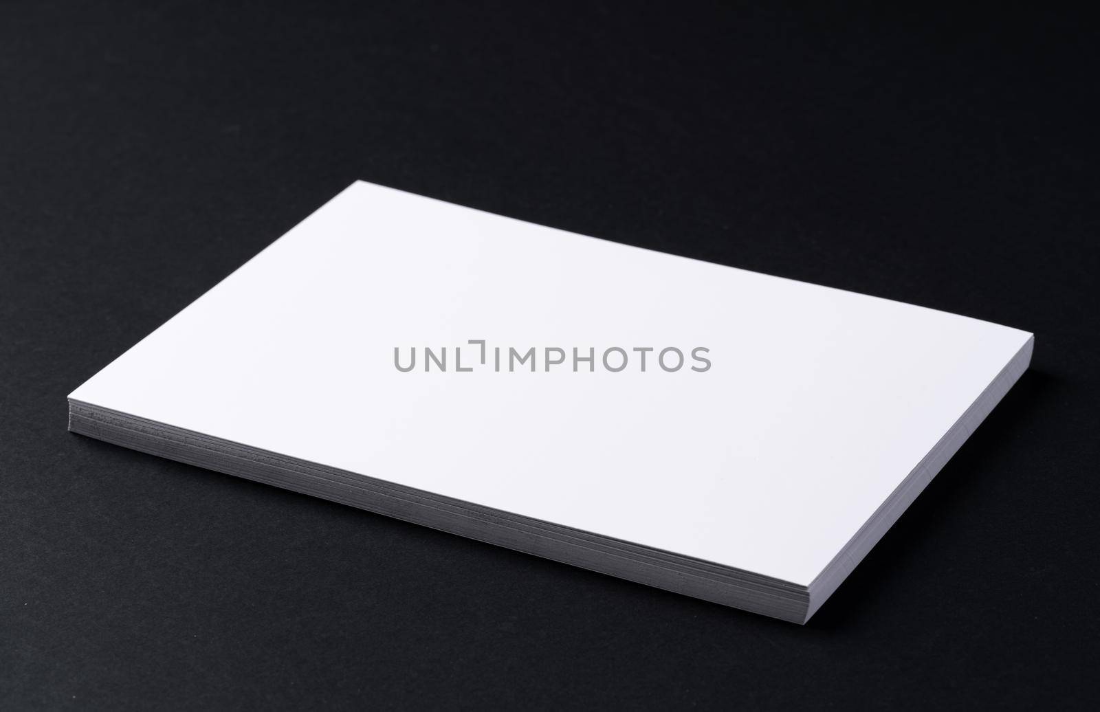 White blank business cards on dark black background, copy space