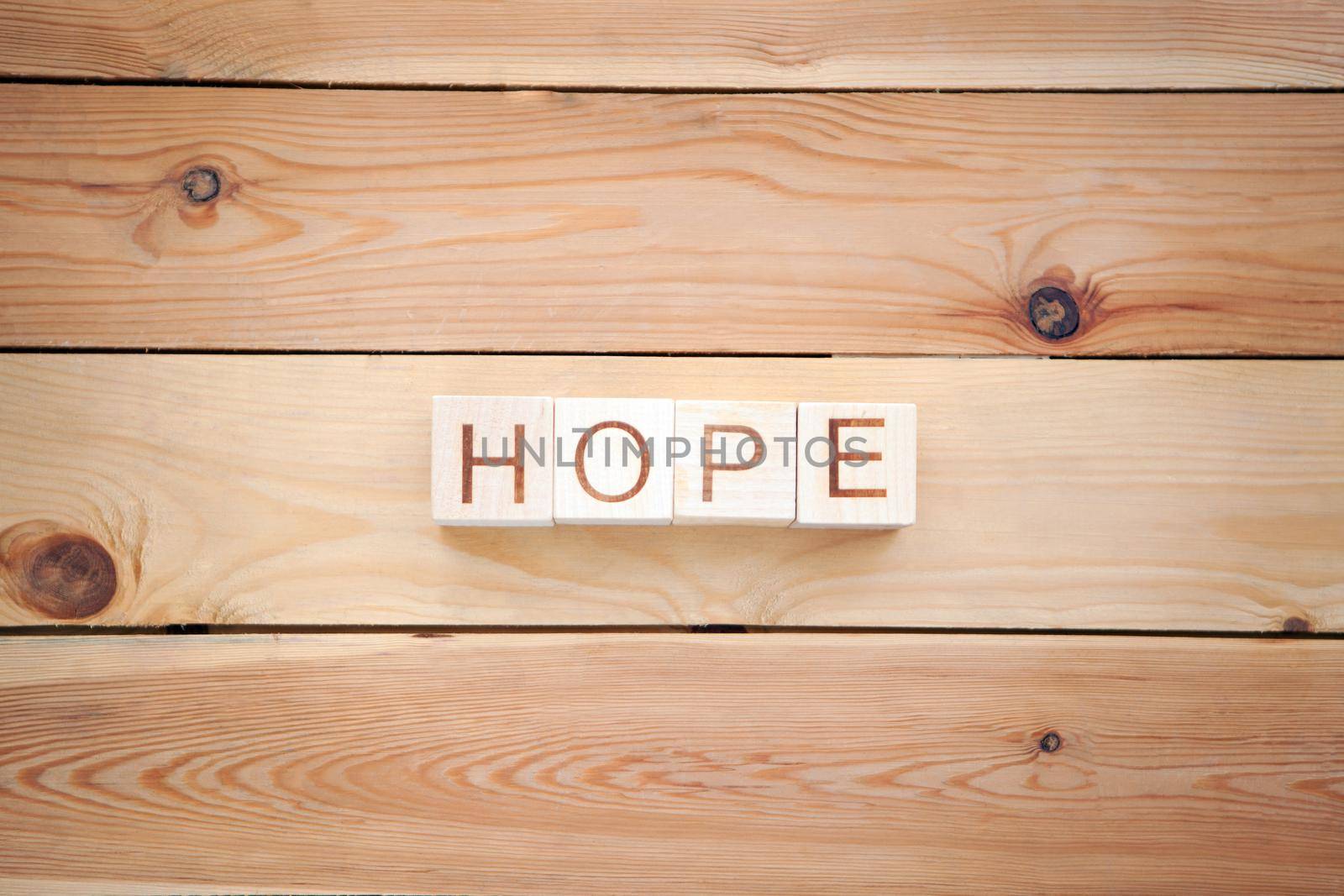 word HOPE at the wooden cubes on wooden backgroung - concept picture about hope and faith