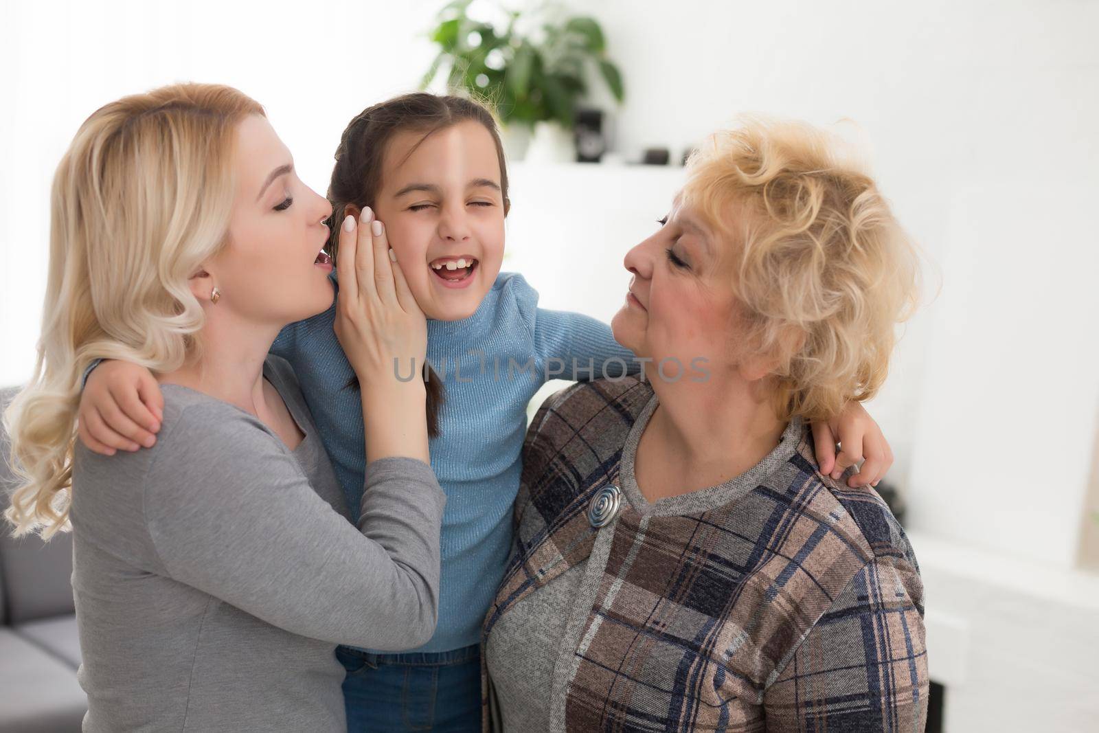 Portrait of three generations of women look at camera posing for family picture, cute little girl hug mom and granny enjoy time at home, smiling mother, daughter and grandmother spend weekend together by Andelov13