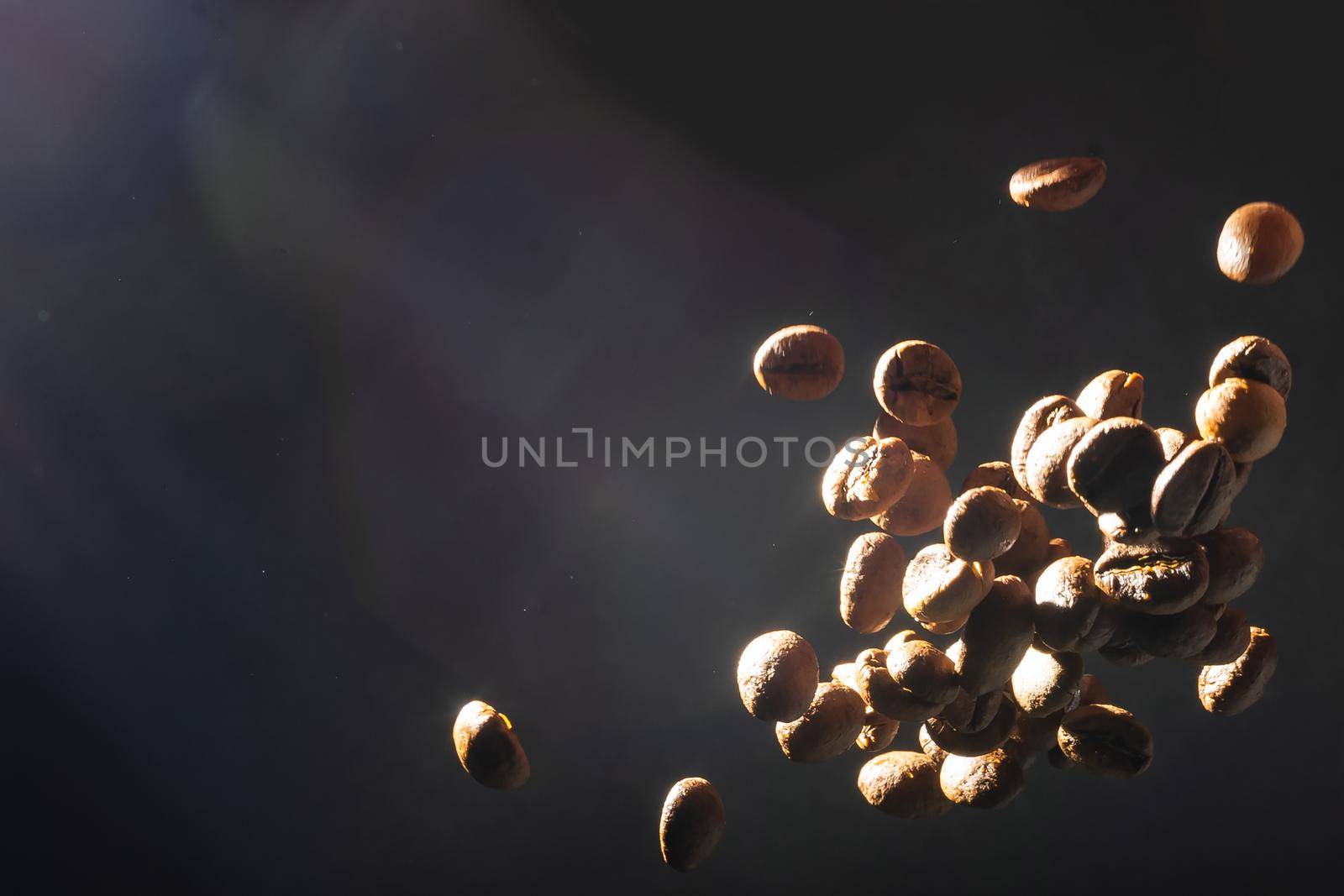 many flying coffee beans on black background.