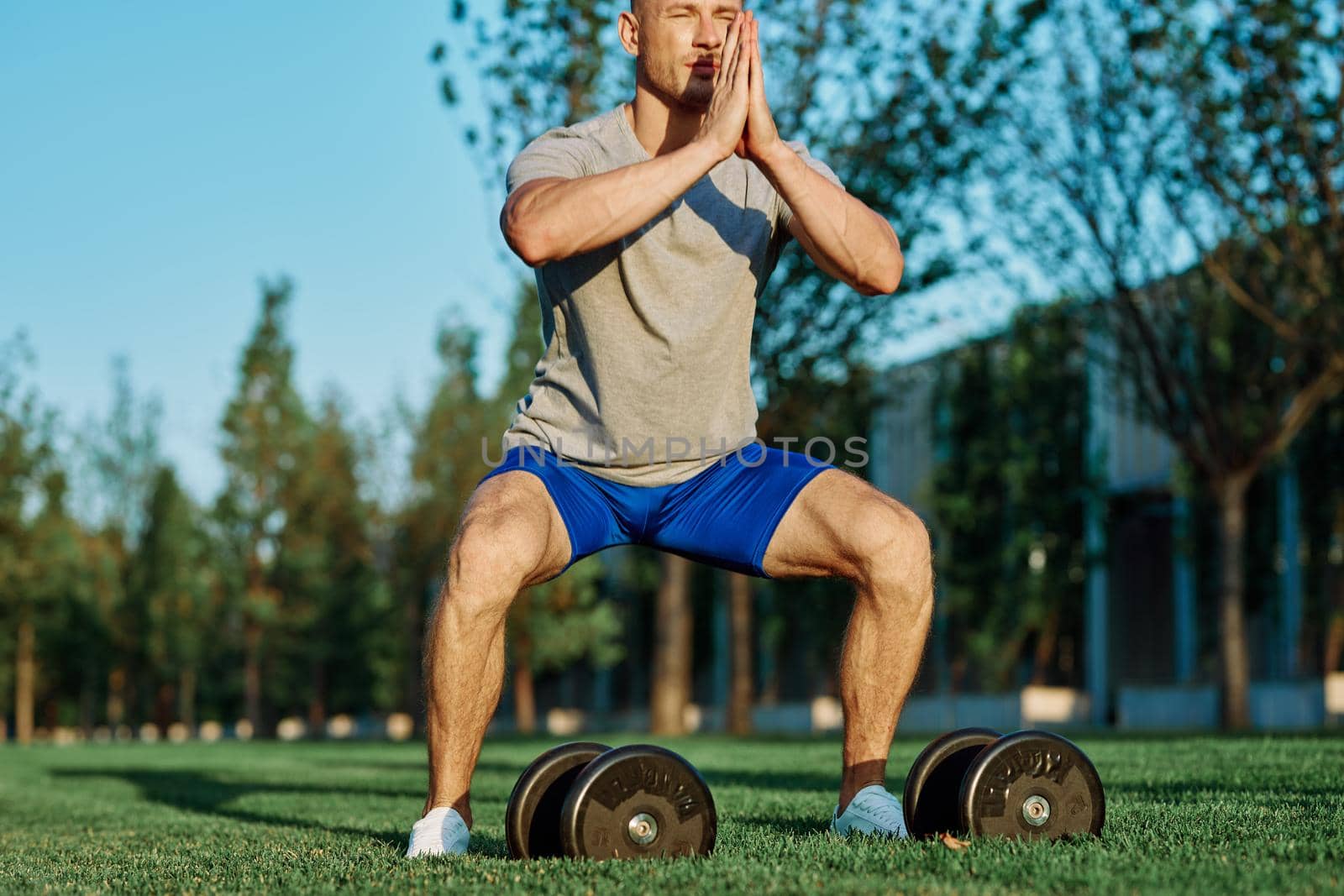 male athlete park with dumbbells doing CrossFit exercise by Vichizh