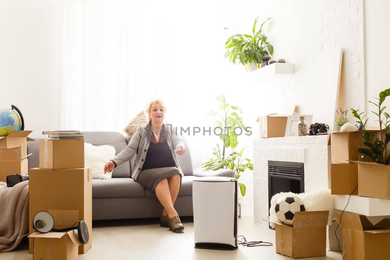 elderly woman next to an air purifier moving to a new apartment