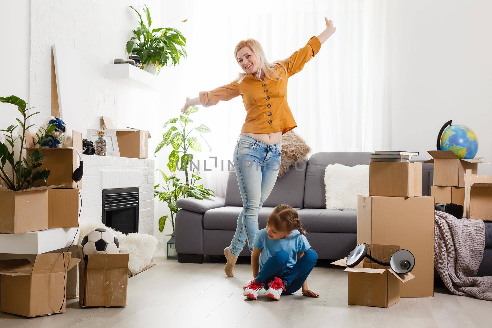 happy family moves into a new apartment. happy girl near cardboard box