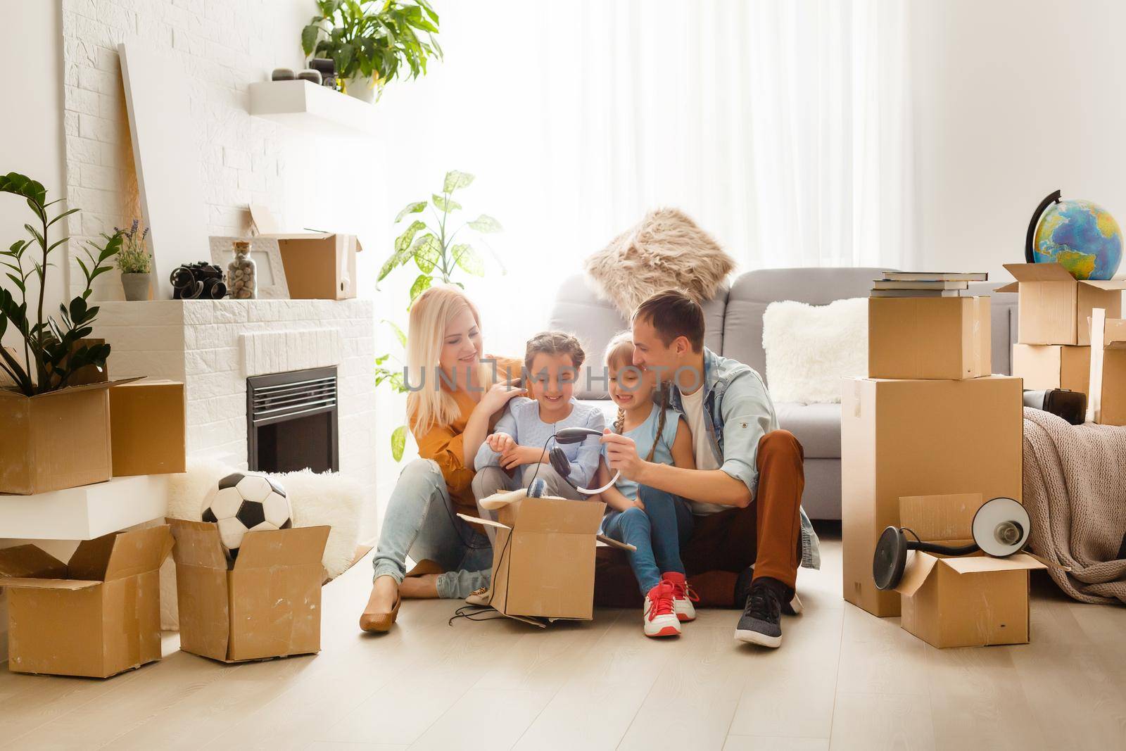 Happy family with cardboard boxes in new house at moving day. by Andelov13