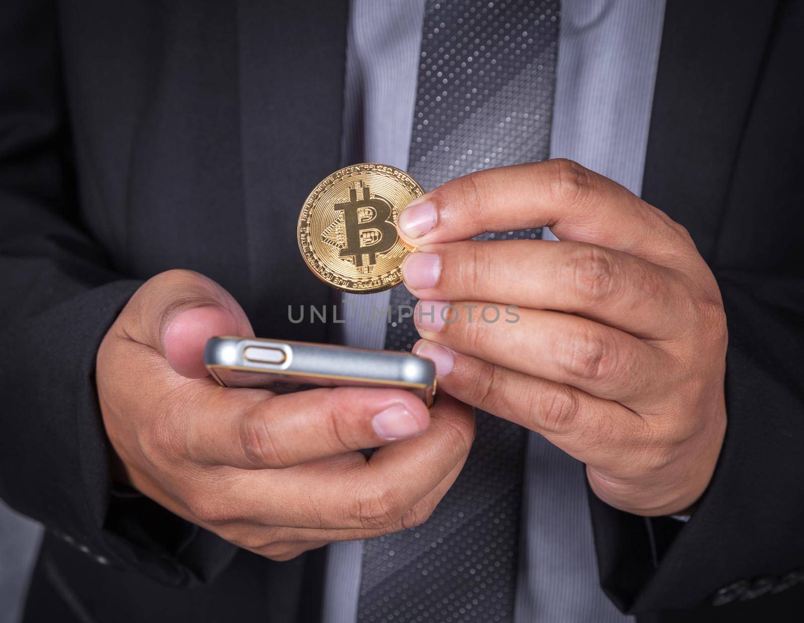 close up business man with bitcoin and using a mobile phone