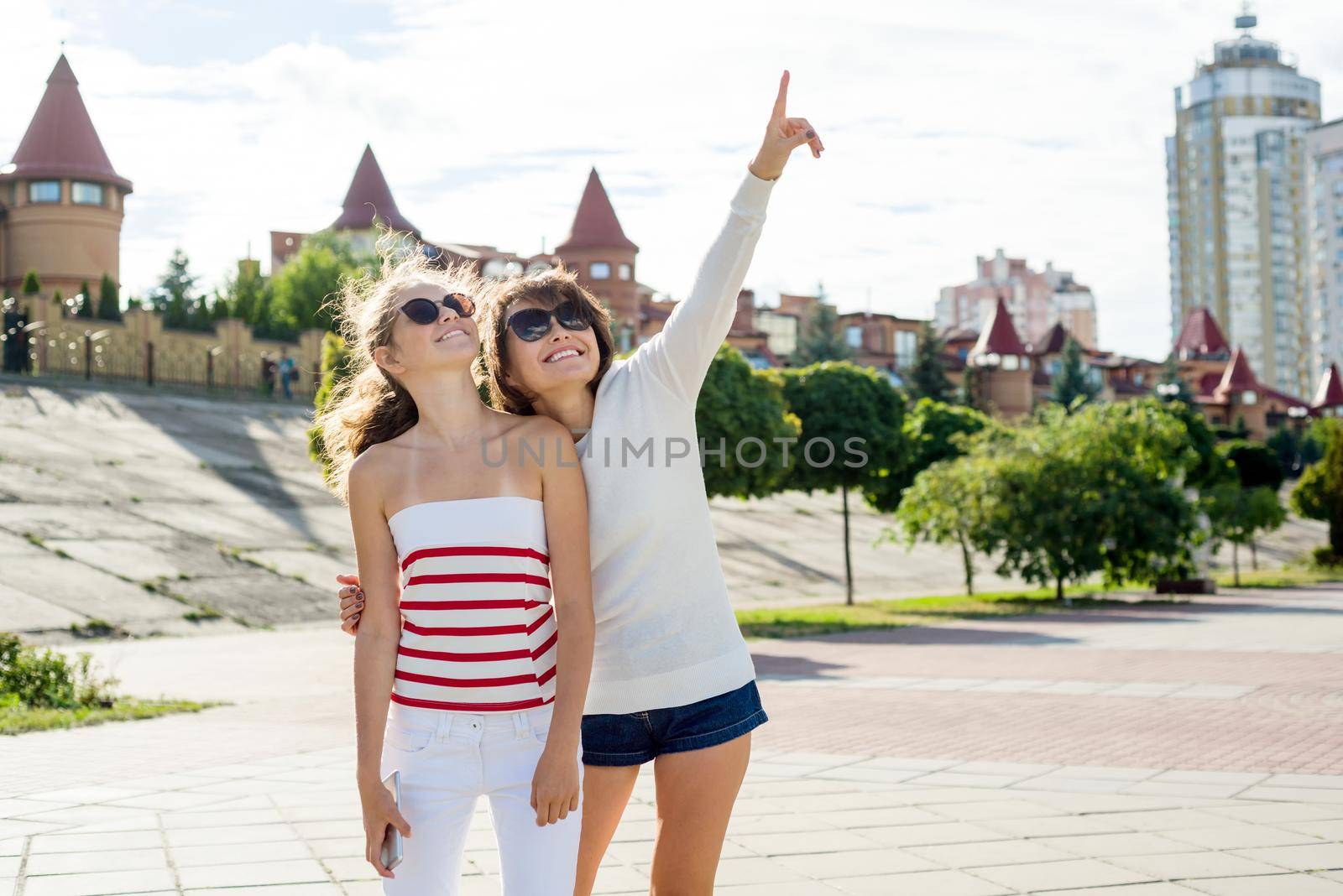 Communication between the mother and the teen daughter. City sunset background.