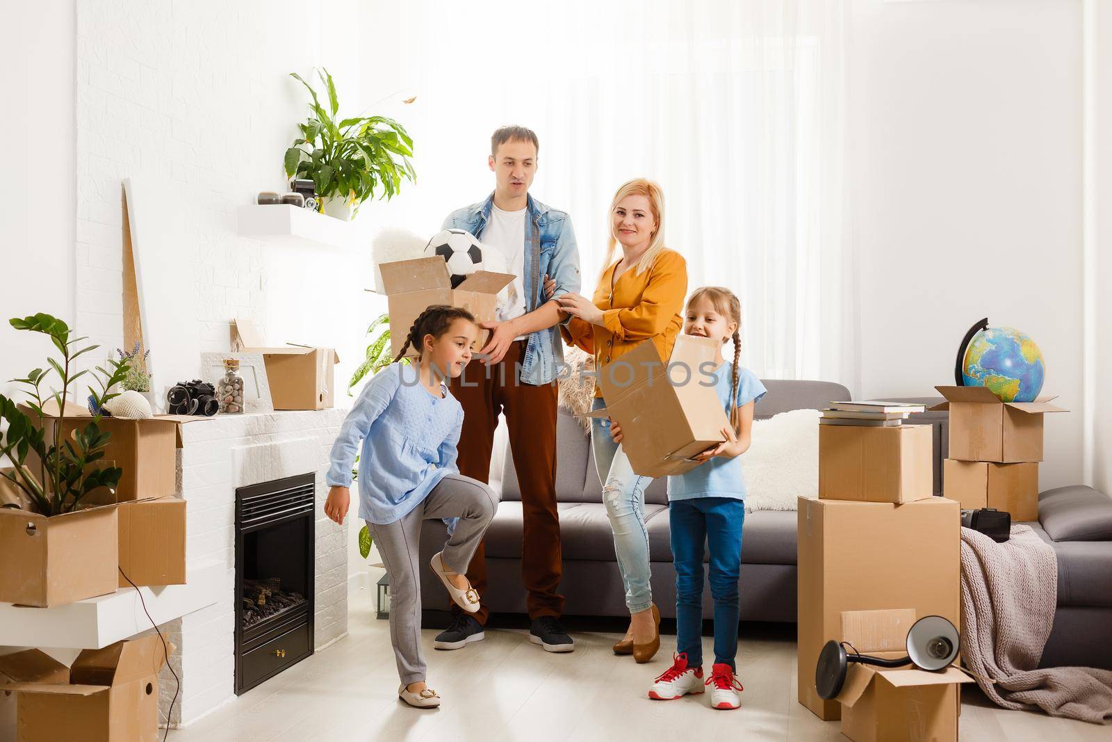 Happy family with cardboard boxes in new house at moving day.