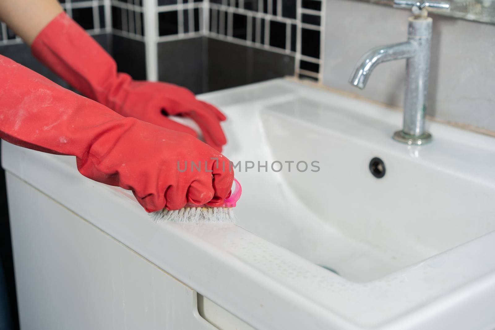 hand cleaning bathroom sink with a brush