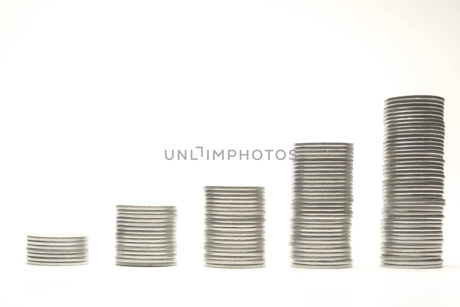 Stacks of silver coins in the form of the diagram, isolated over white background. Shallow DOF.