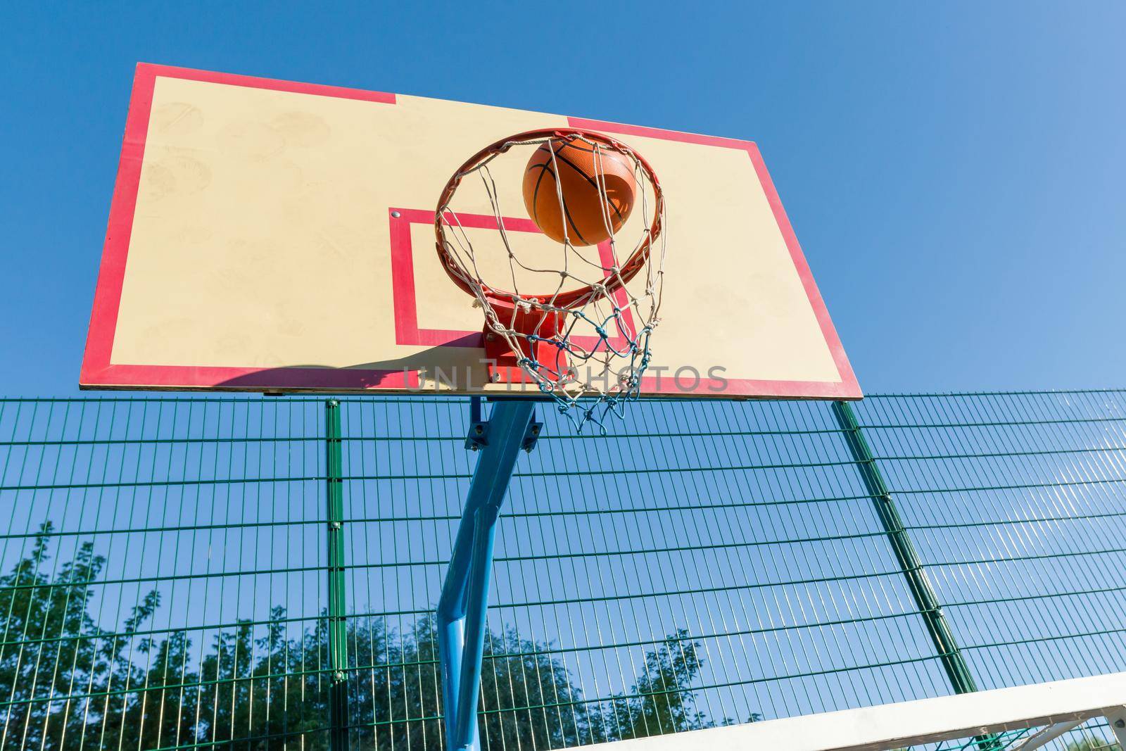 Street basketball, close-up of basketball ring and ball flying into the basket