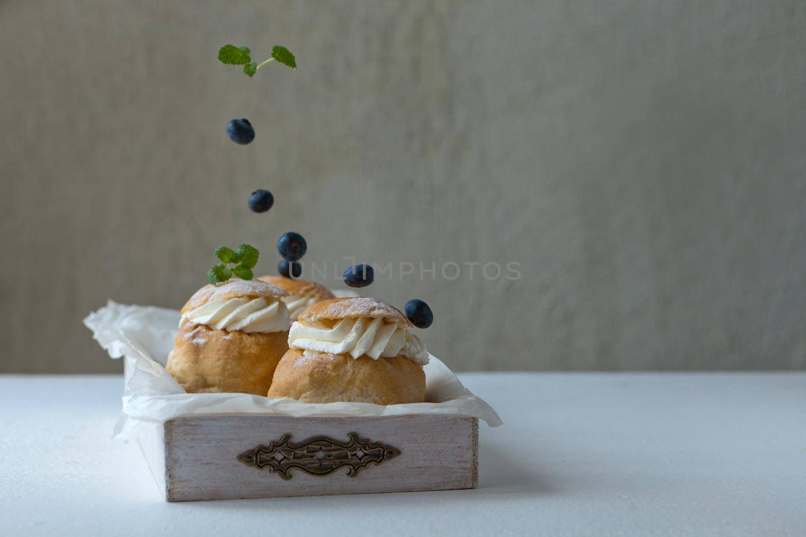 Fresh baked homemade buns with blackberries on the table for breakfast Baking traditional Swedish semla bread for Throve thursday. food concept