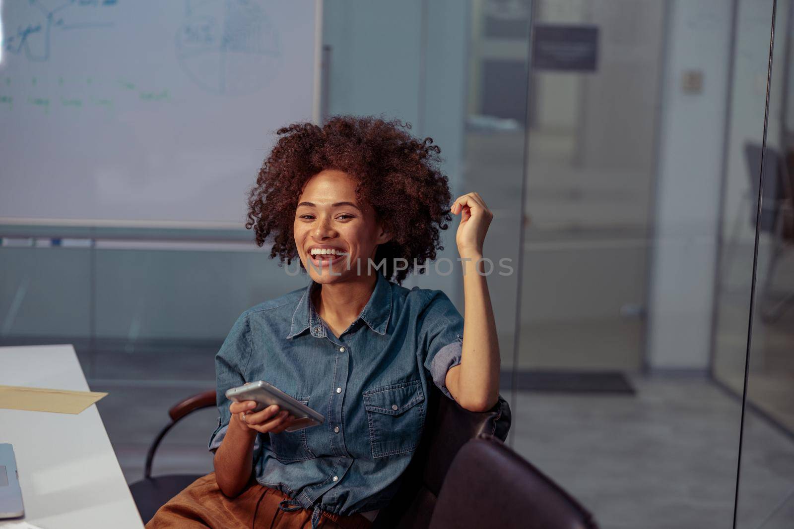 Smiling pretty lady sitting on chair in the meeting room by Yaroslav_astakhov