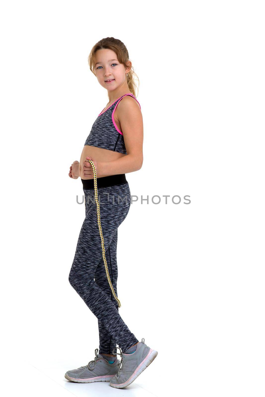 Girl performing exercise with jumping rope. Studio portrait. by kolesnikov_studio