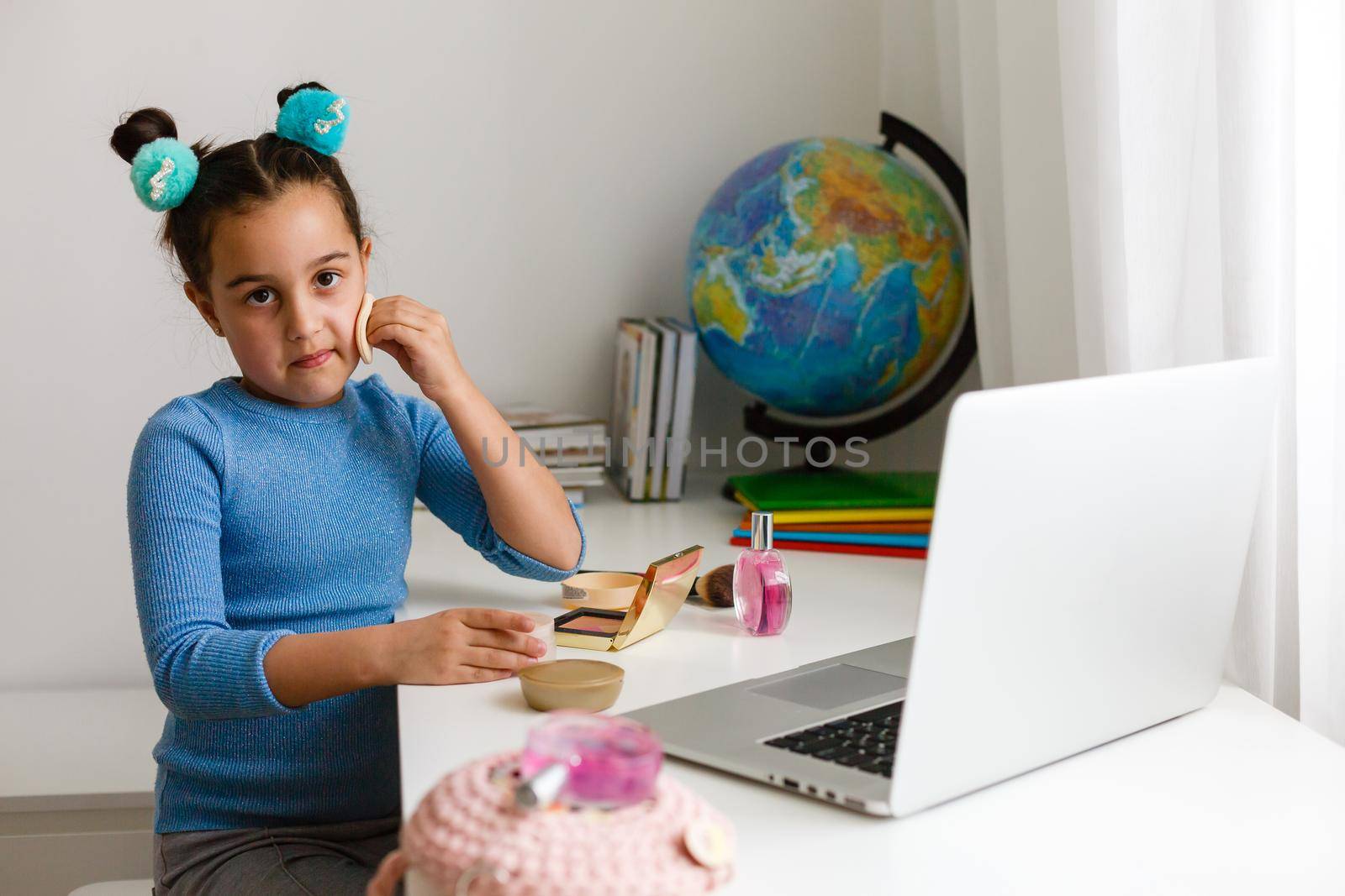little girl learning make-up on laptop online, distance learning