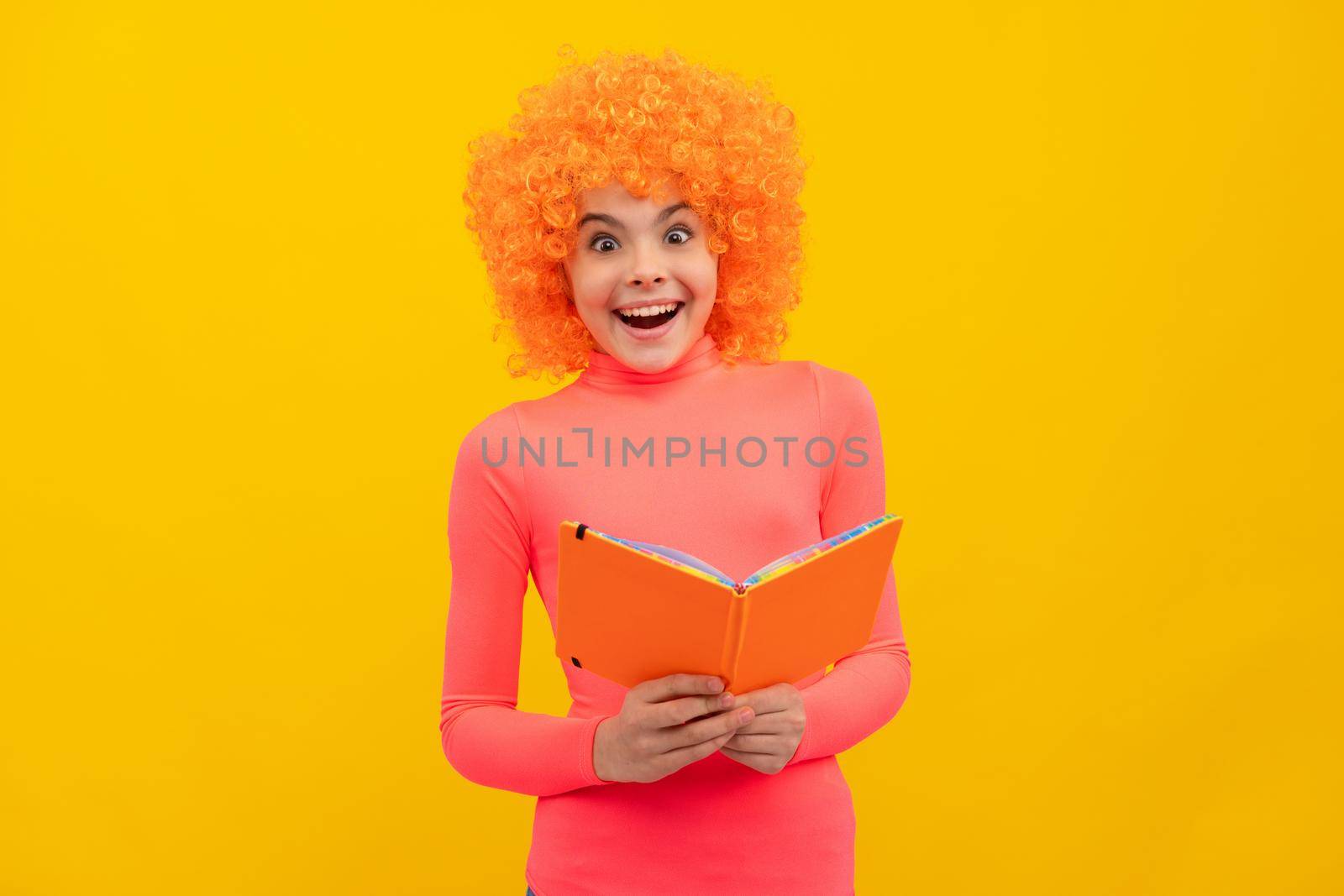 Happy girl child with orange hair in pink poloneck smile holding school book, education by RedFoxStudio