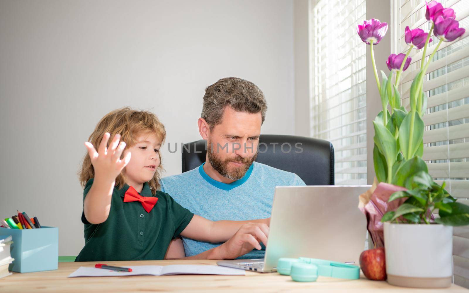 bearded dad or school private tutor teaching boy son with modern laptop, e-learning by RedFoxStudio