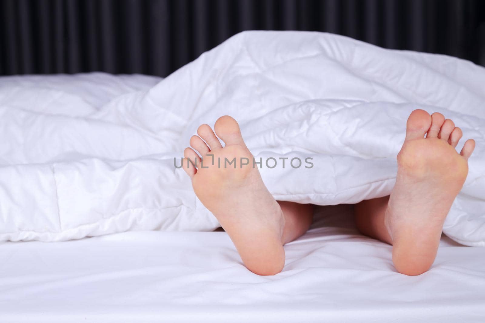 close up of two feet in a bed