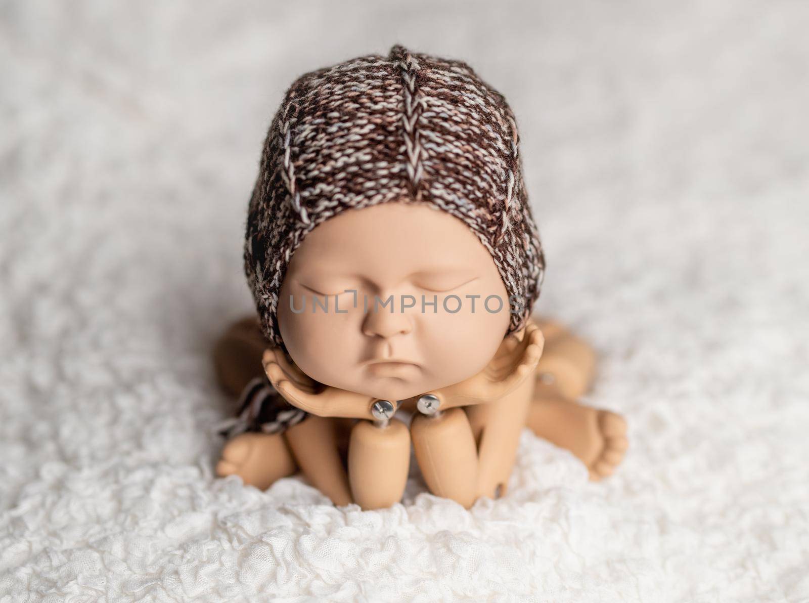 Plastic mannequin of baby, made for posing, in frog stand, isolated