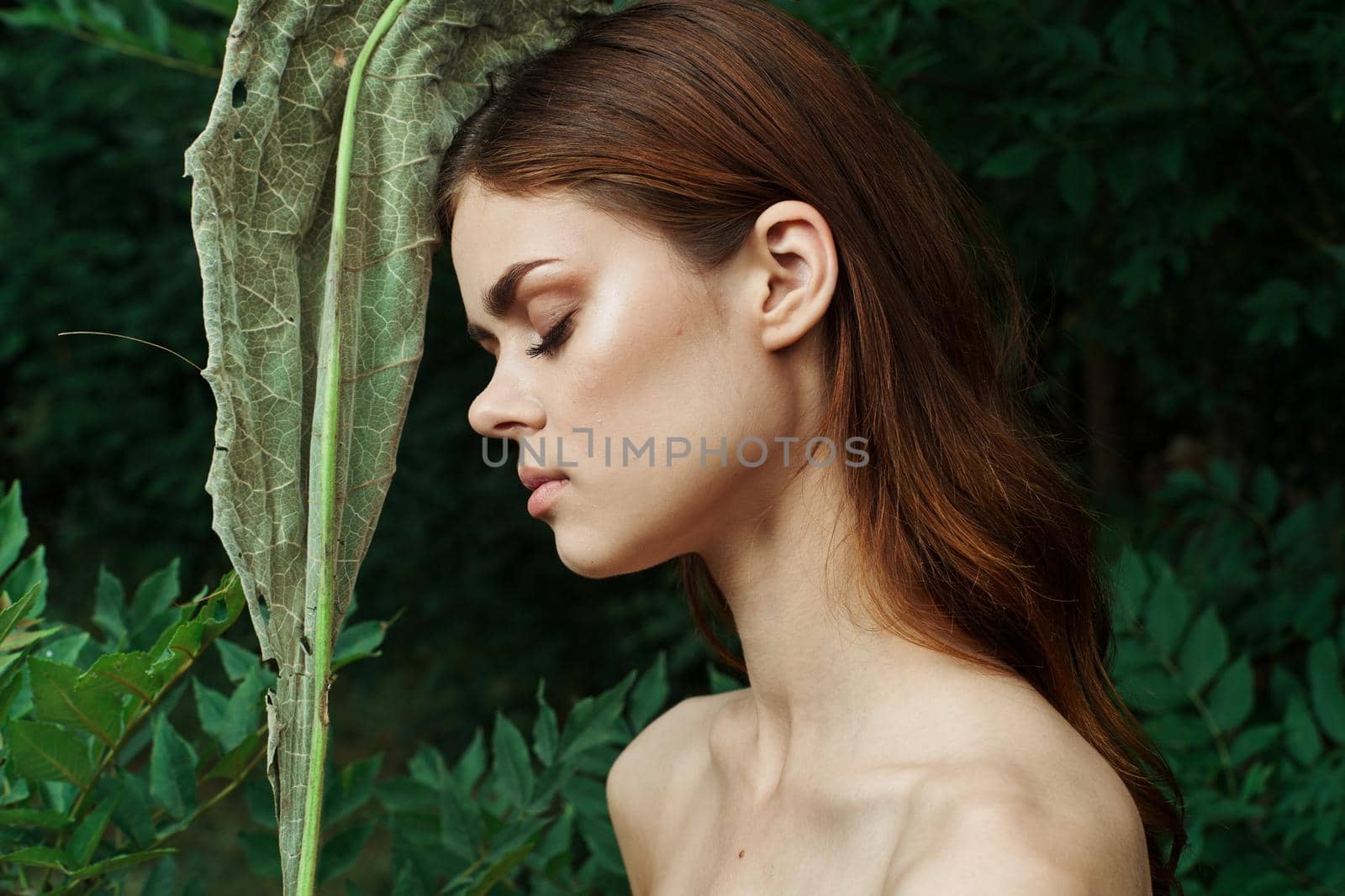pretty woman bared shoulders green bush cosmetics cropped view. High quality photo