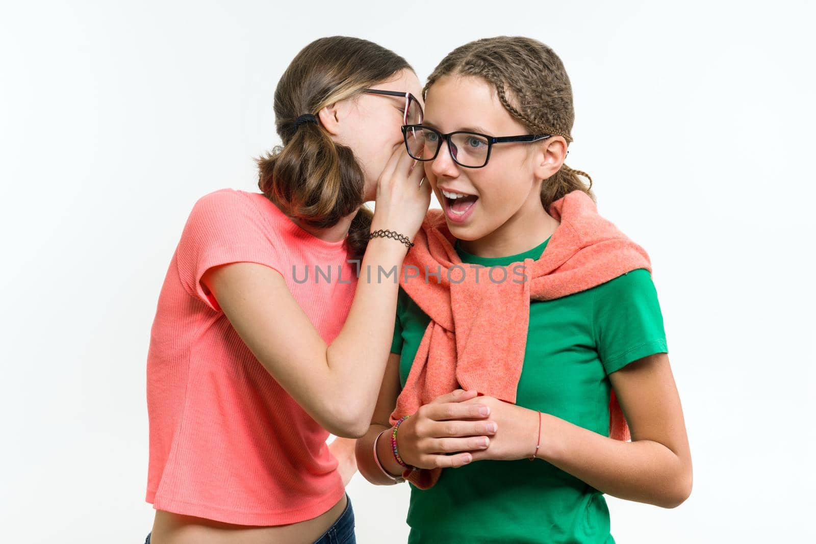 Portrait of two 12-13 year old girls. Beautiful teenage girlfriends communicate, secrete and smiling