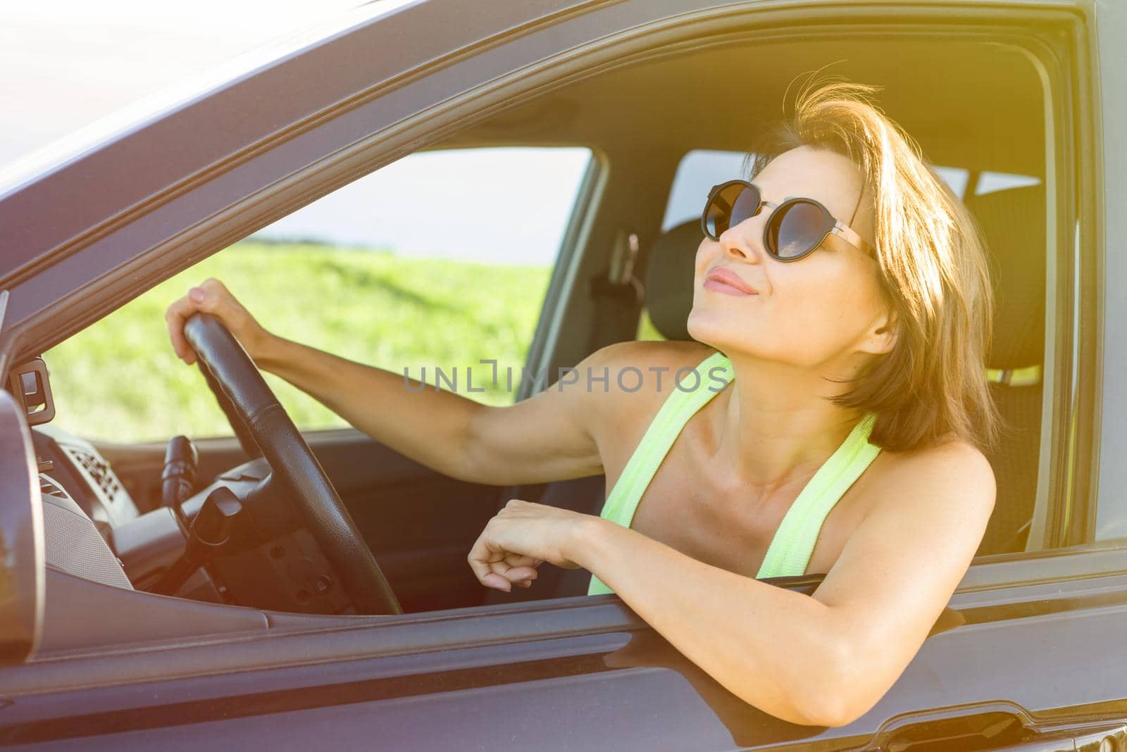 Beautiful female driver smiling while driving his car