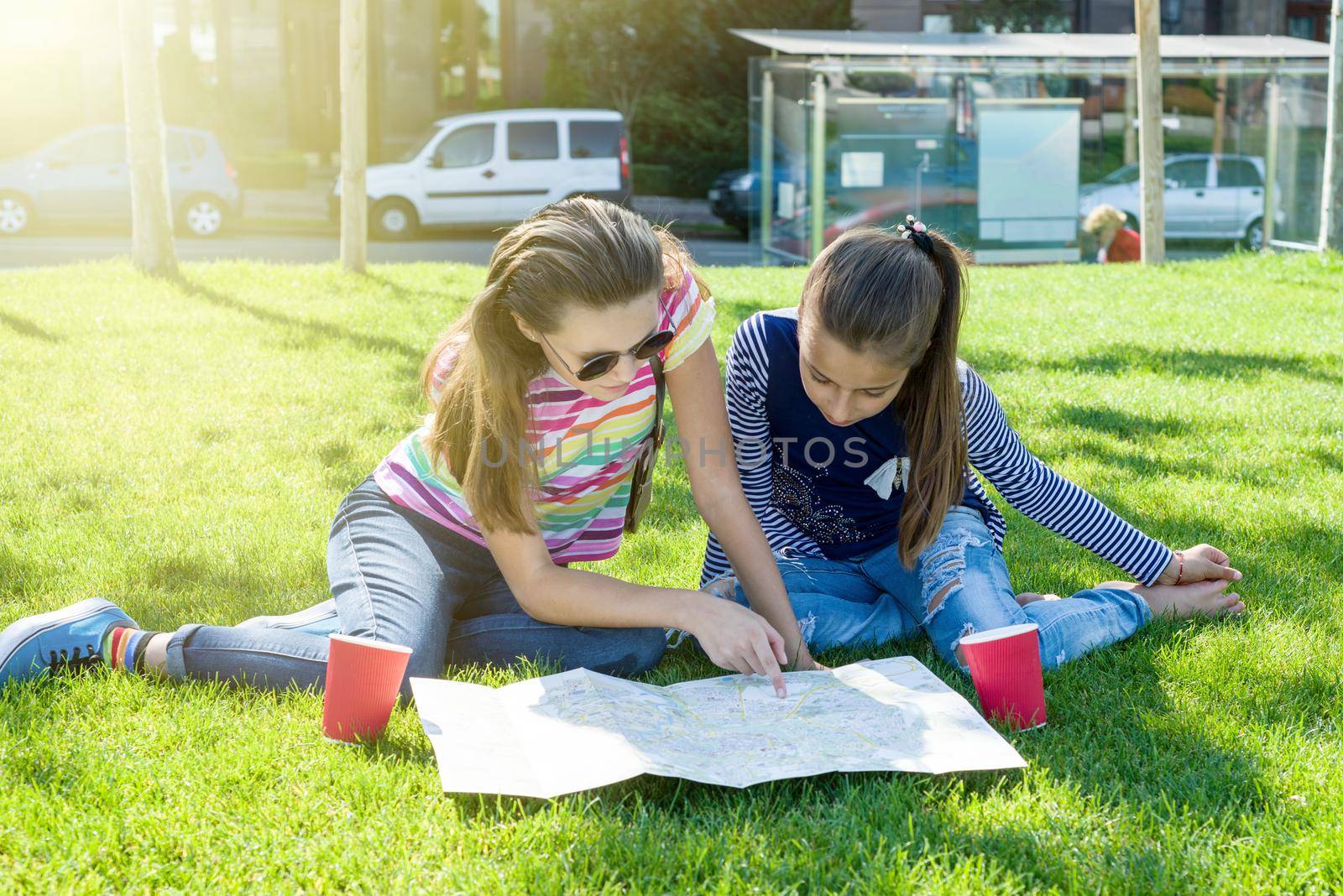 Young cute girls teens with map of european city outdoors