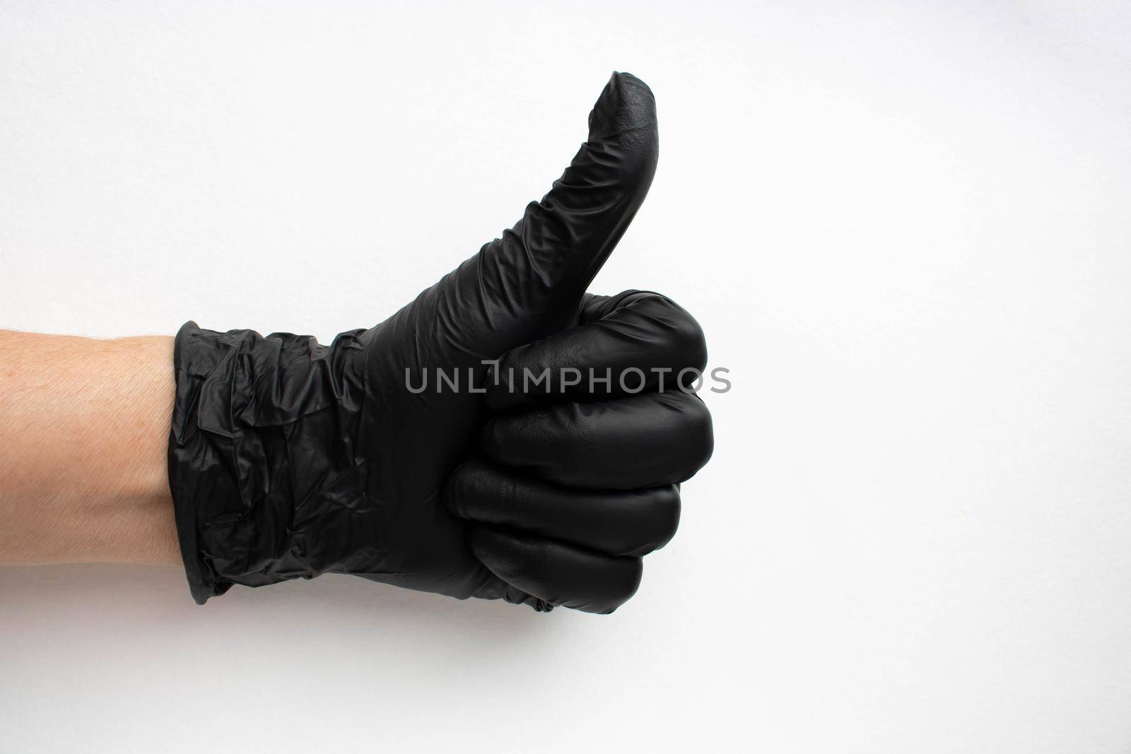 Hand in a black surgical medical glove, isolated on a white background. Production of rubber protective gloves.Hygiene and sanitary standards.
