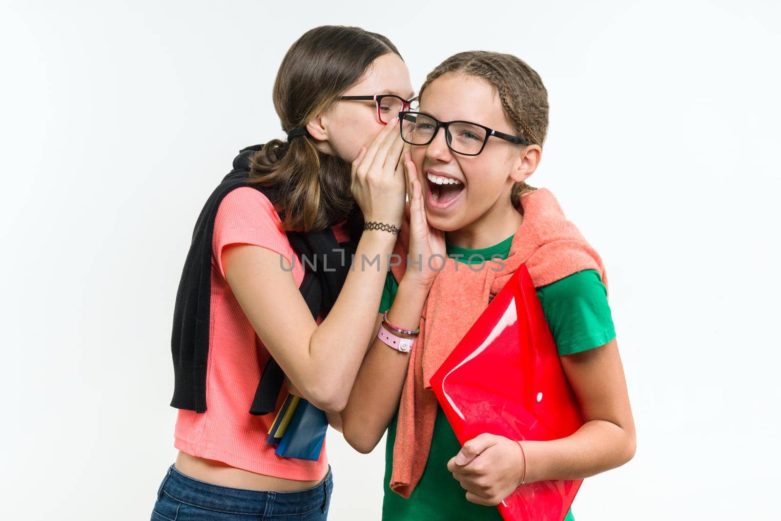 Happy high school friends are teenage girls, talk and secret. White background, with books and notebooks.