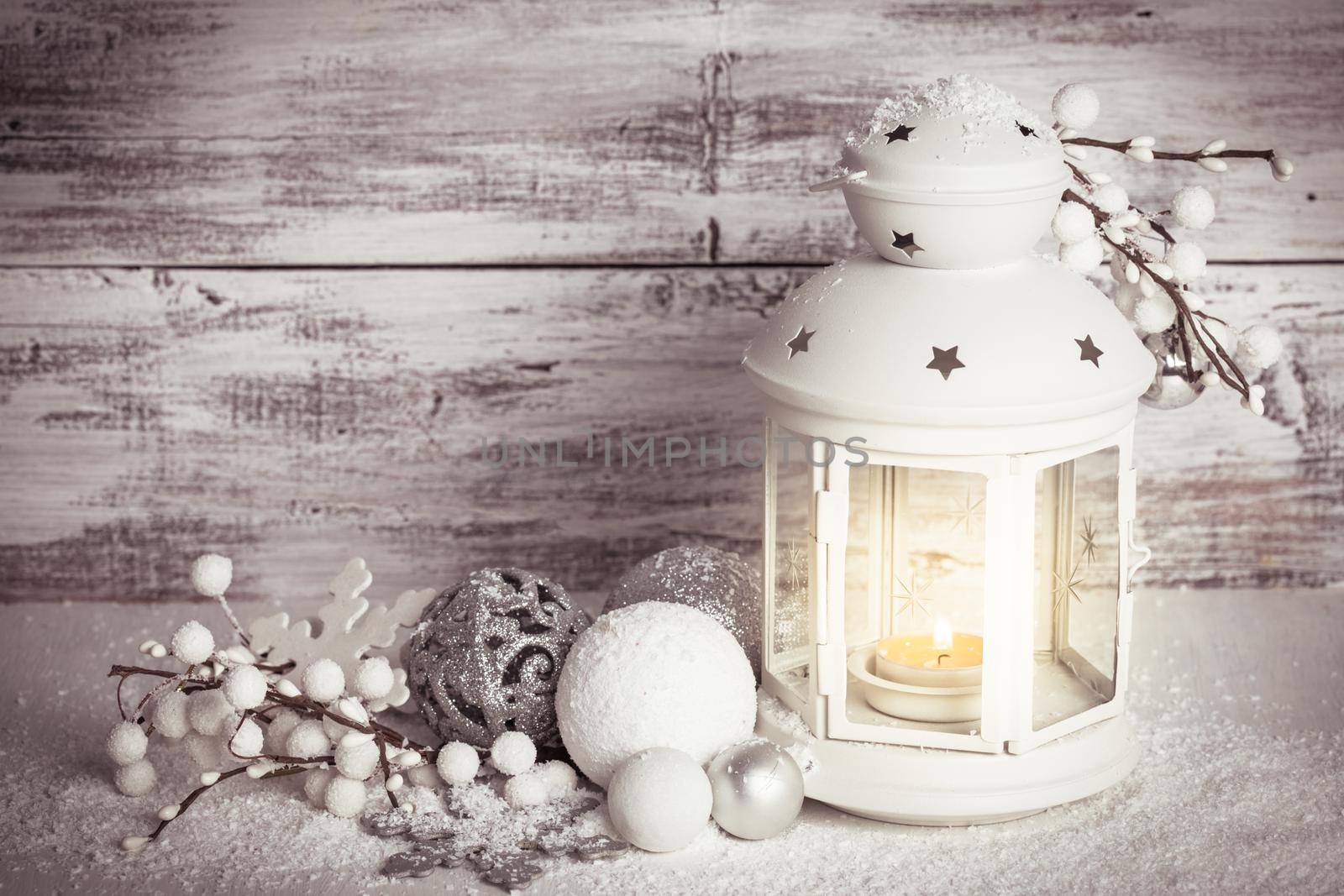 Cristmas lantern with decorations and snow over white shabby wooden background