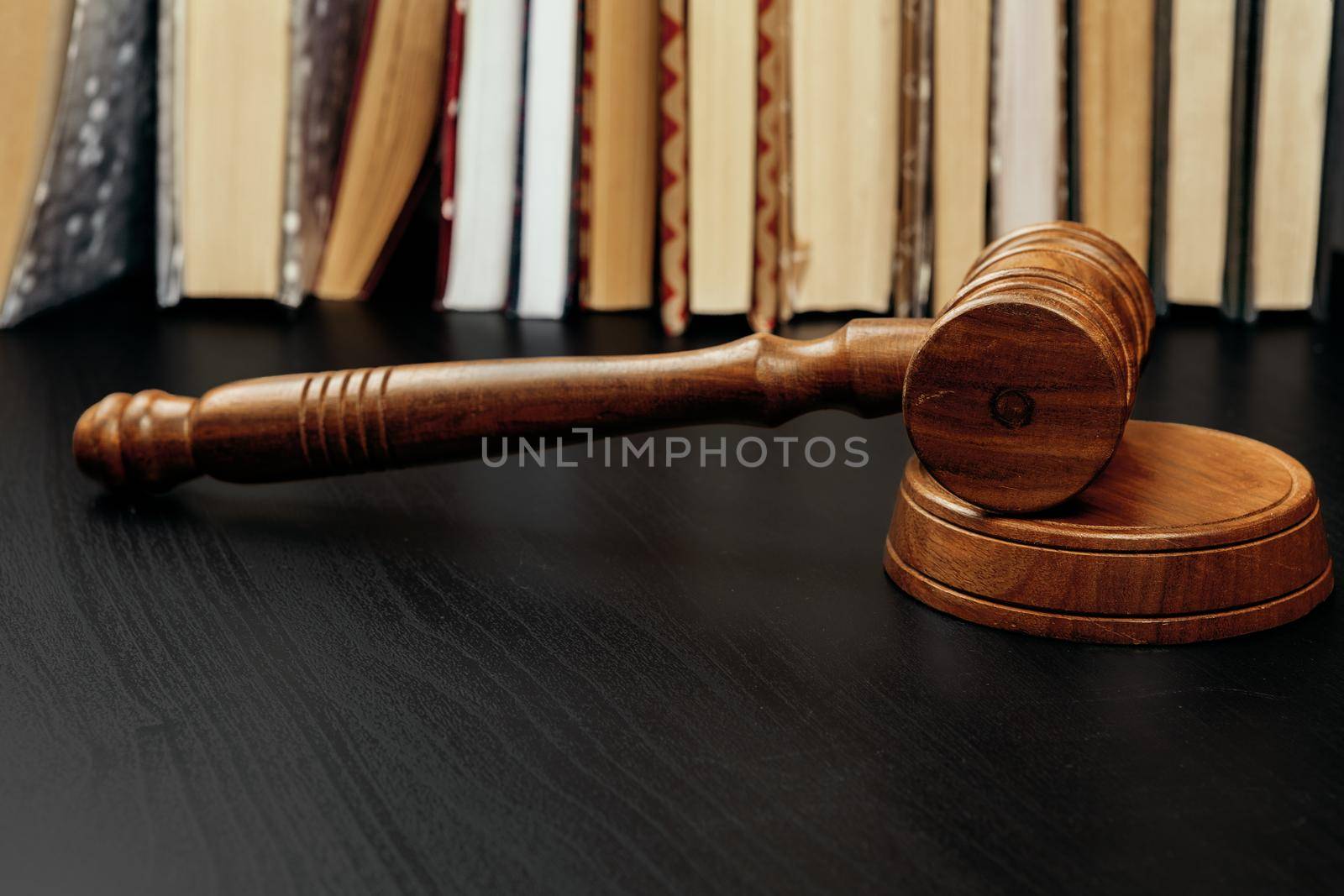 Judge's gavel on wooden table in dark. Close up.