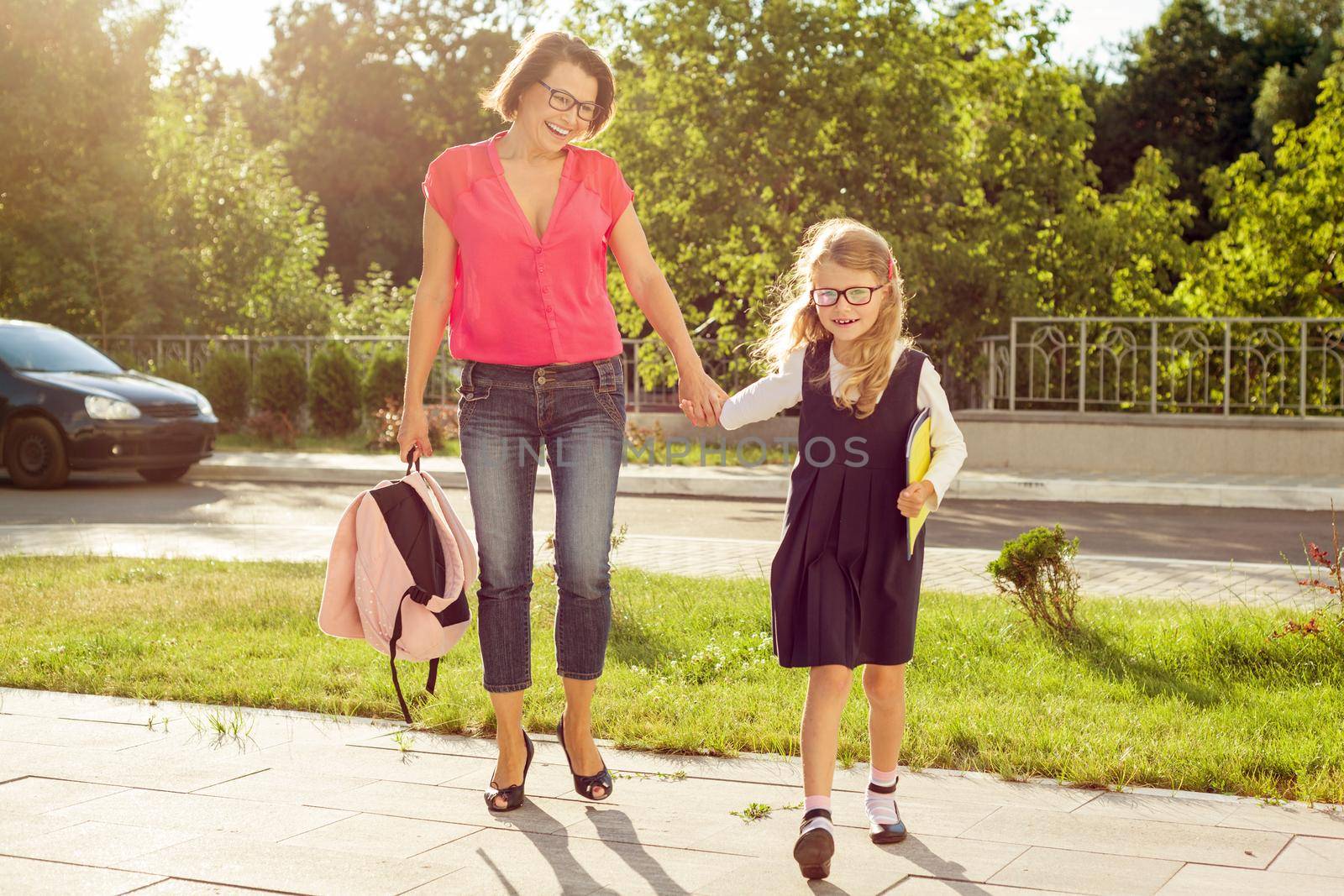 Mother and daughter student walking to school. Back to school